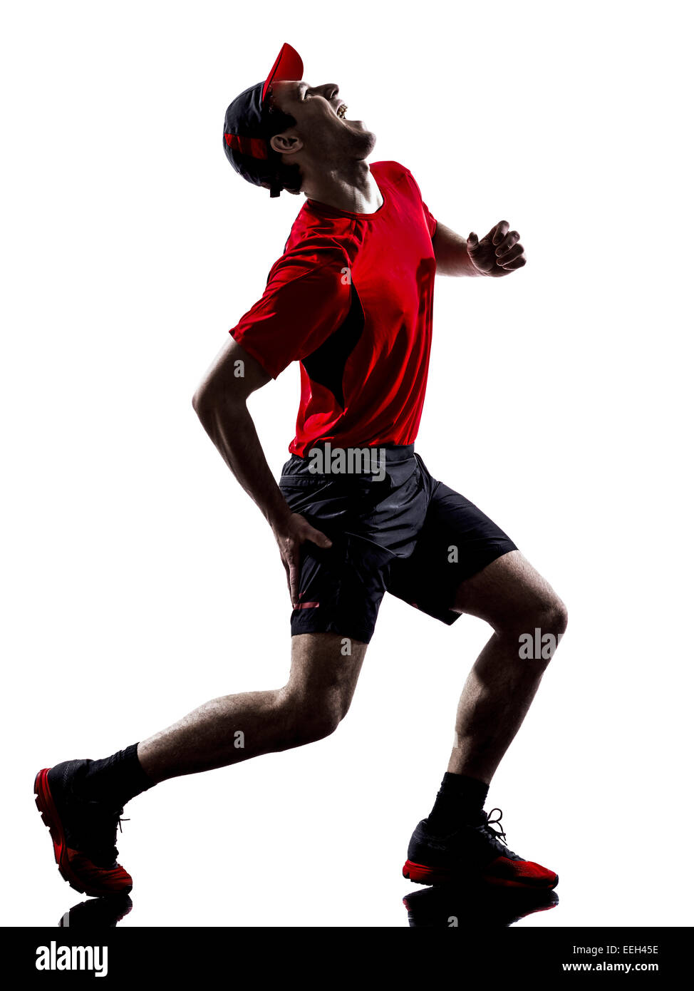 Un jeune homme runner jogger exécutant la douleur des blessures crampes dans ossature isolé sur fond blanc Banque D'Images