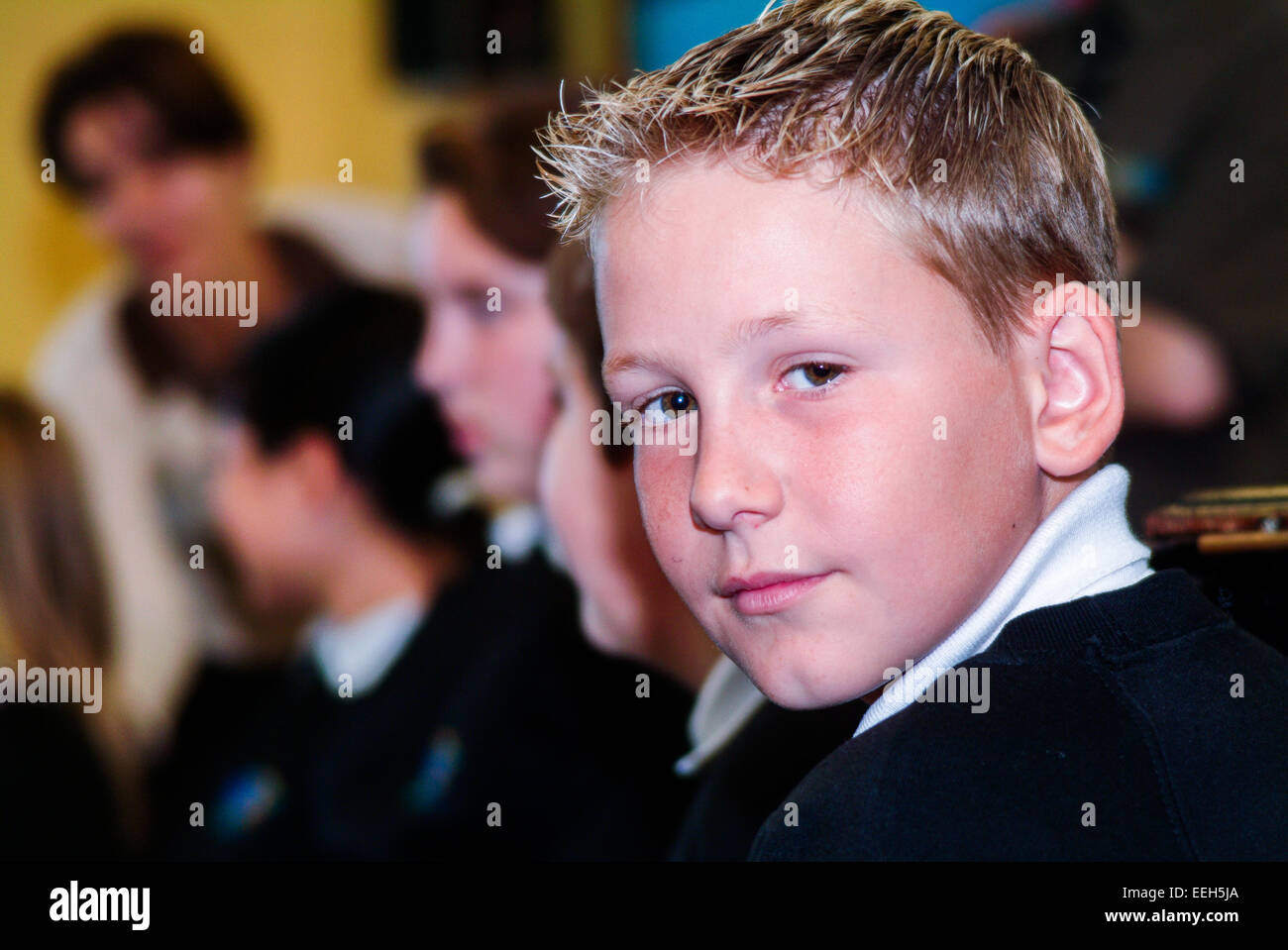 Garçon en classe avec un enseignant en arrière-plan Banque D'Images