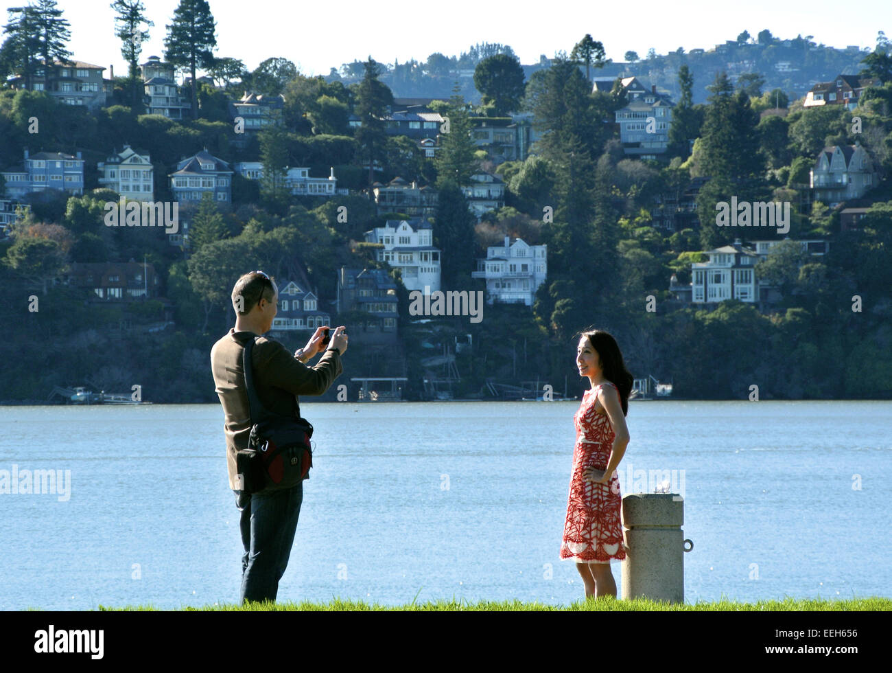 L'homme prend la photo d'une femme en Californie avec Belvedere Tiburon Island dans l'arrière-plan Banque D'Images