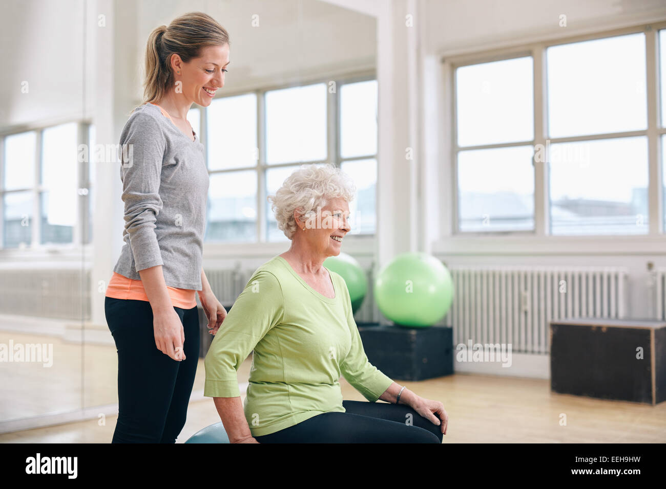 Portrait de femme aide instructeur senior woman in gym. Deux femme fitness club de santé à faire de l'exercice. Banque D'Images Portrait de femme aide instructeur senior woman in gym. Deux femme fitness club de santé à faire de l'exercice. Banque D'Images