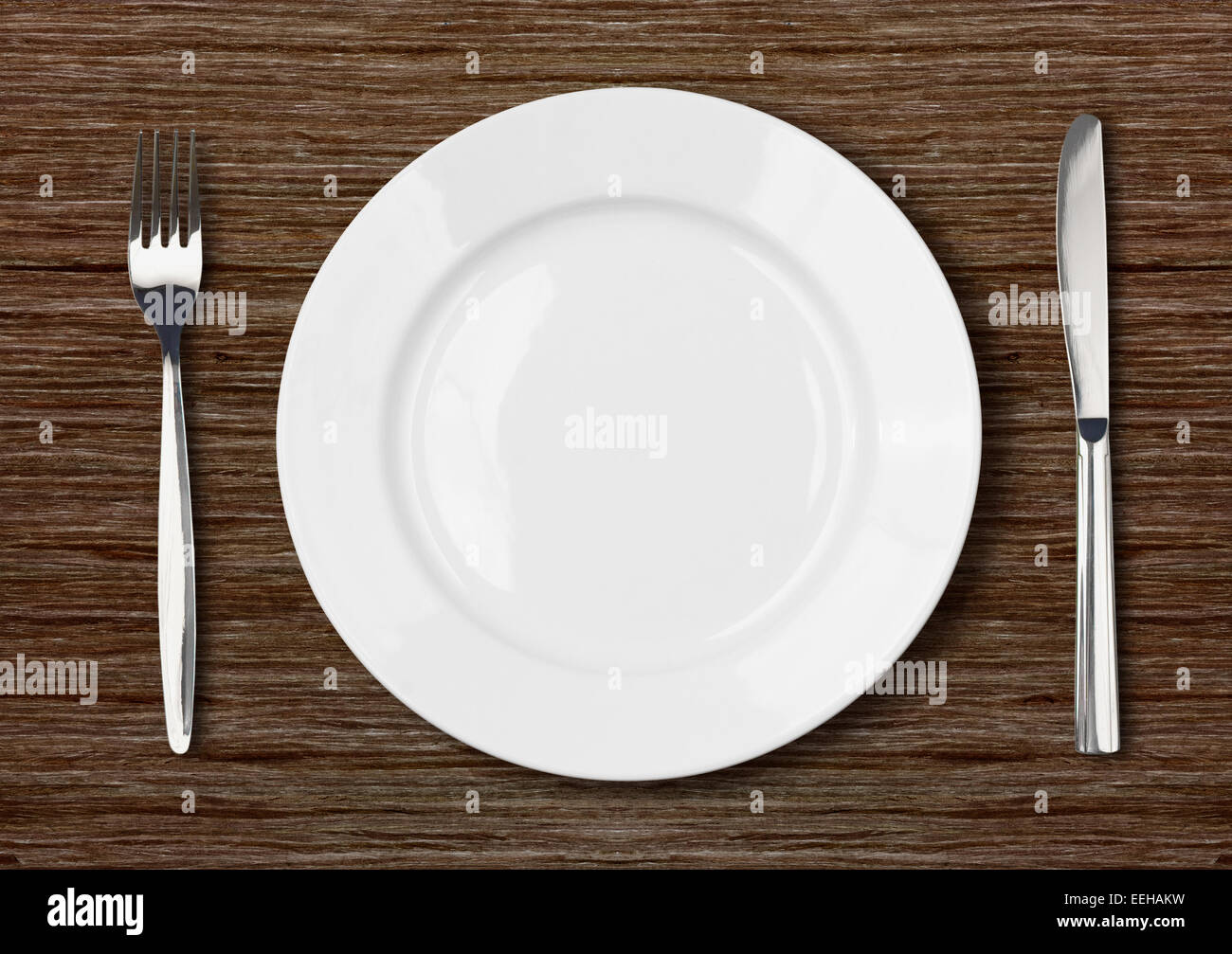 Assiette vide blanc Réglage sur table en bois foncé Banque D'Images