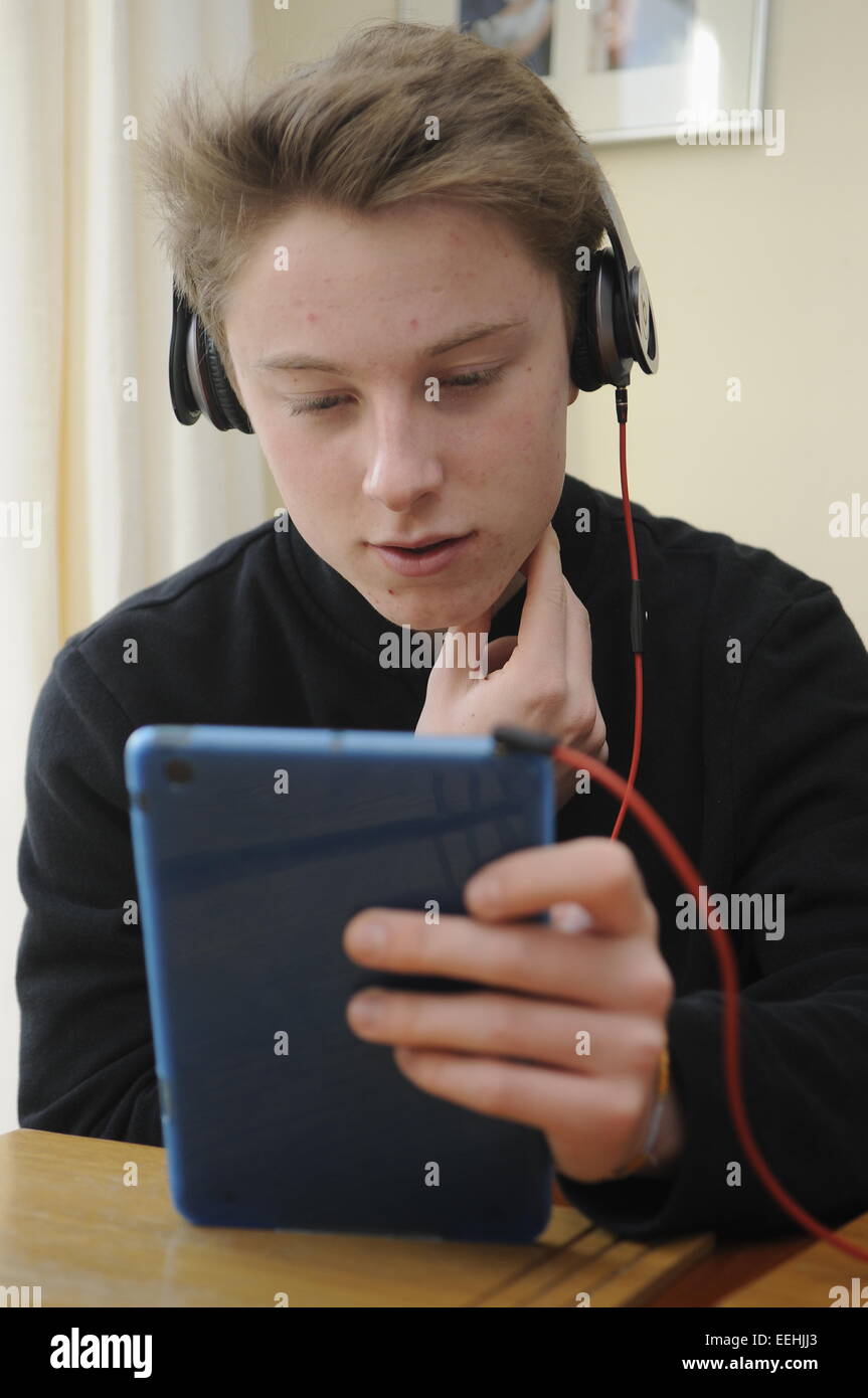 Teenage Boy en utilisant un Apple iPad Mini et écouteurs Beats Banque D'Images