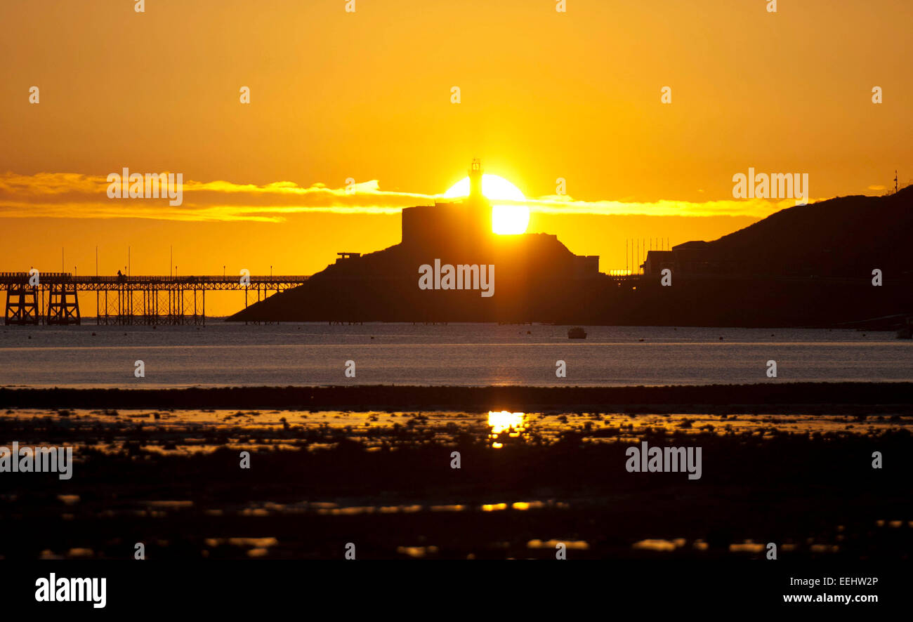 Swansea, Royaume-Uni. 19 Jan, 2015. Météo France : Le soleil se lève derrière le phare emblématique dans le petit village de Mumbles près de Swansea au début d'un hivers matin croquant. Credit : Phil Rees/Alamy Live News Banque D'Images