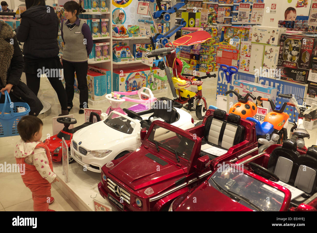 Une petite fille regarde petites voitures dans un magasin de jouets à Beijing, Chine.17-Jan-2015 Banque D'Images