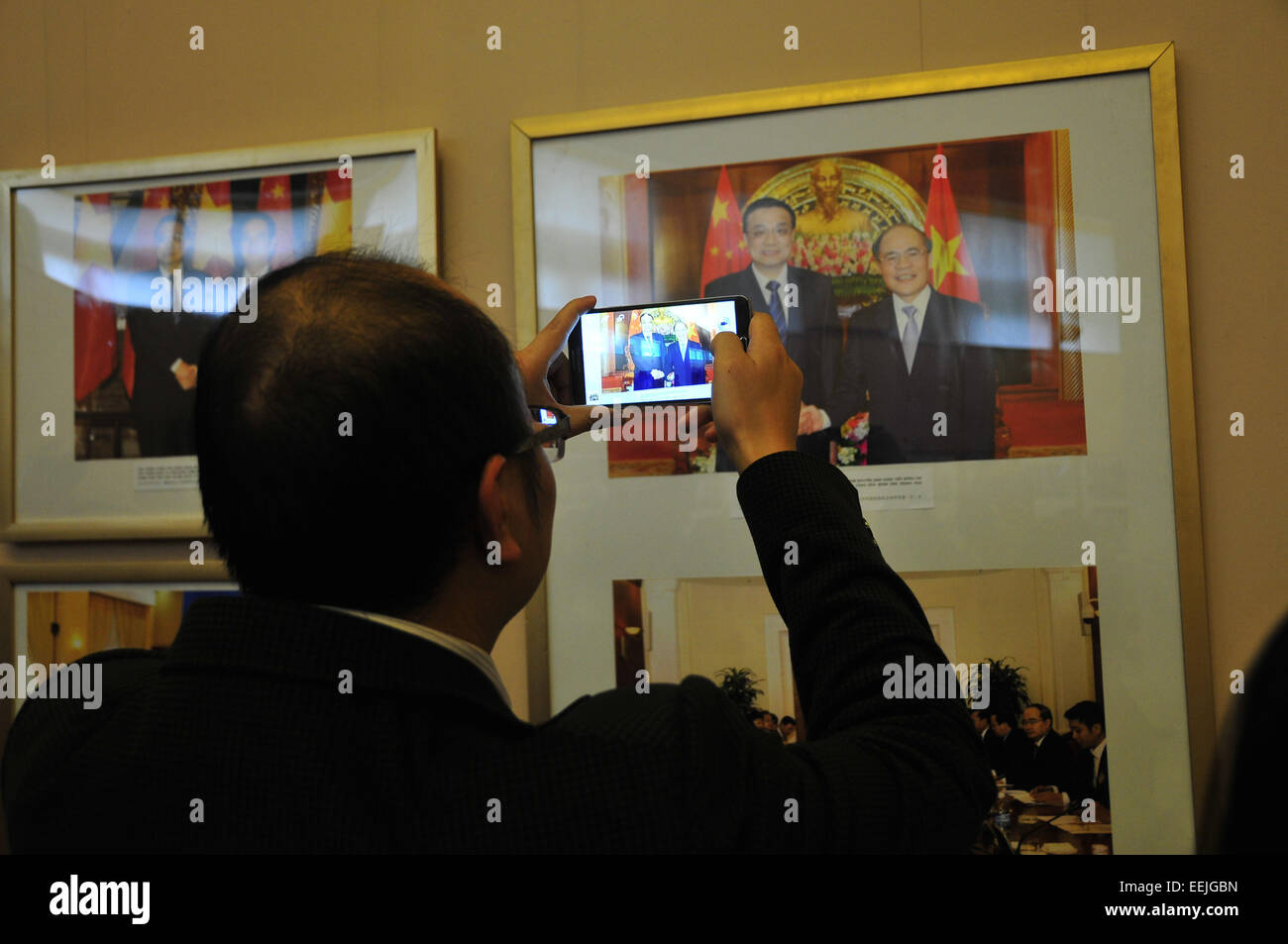 Hanoi, Vietnam. 19 Jan, 2015. Un visiteur prend des photos d'images affichées à l'exposition photo à Ho Chi Minh Museum à Hanoi, Vietnam, 19 janvier 2015. Une exposition de photos a été organisée conjointement par l'ambassade de Chine au Vietnam et Ho Chi Minh du Vietnam à Hanoi, Musée pour célébrer le 65e anniversaire de l'établissement de relations diplomatiques entre la Chine et le Vietnam. © Zhang Jianhua/Xinhua/Alamy Live News Banque D'Images