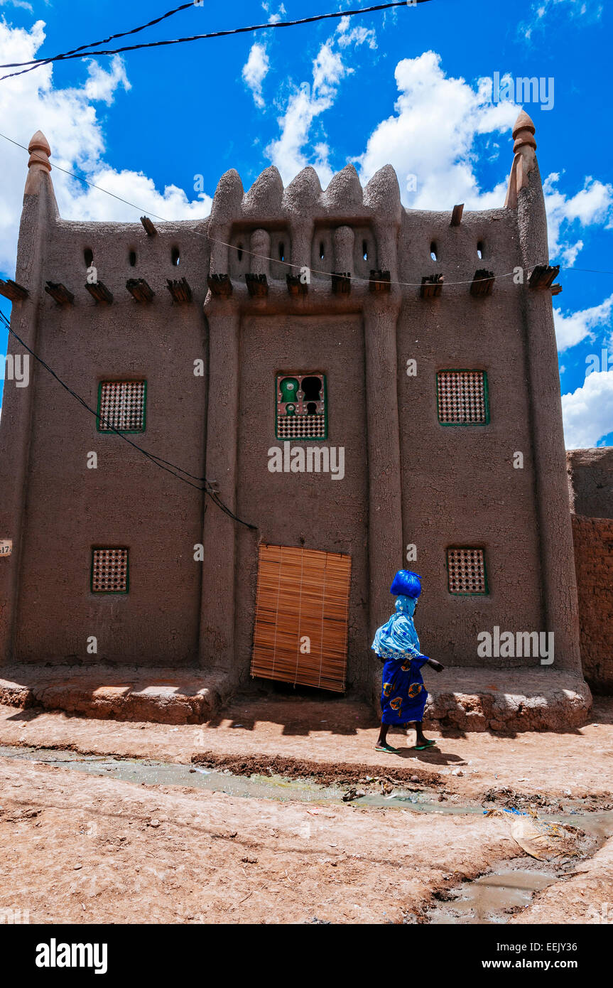 Femme passant d'un bâtiment de style soudanais, Djenné, Mali. Banque D'Images