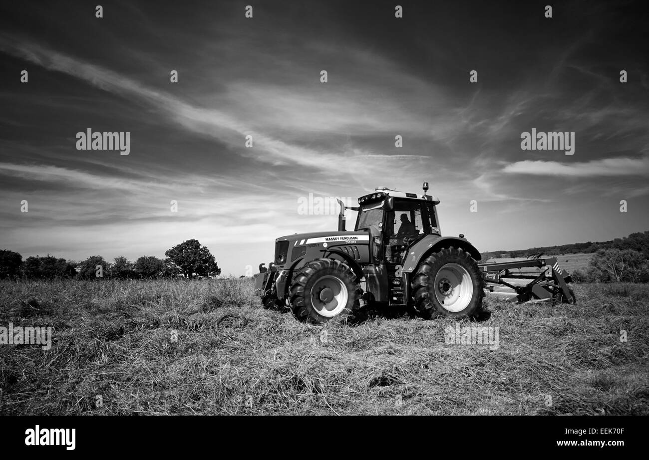 Le fauchage de l'herbe pour l'ensilage agriculteurs en été dans la région de Norfolk, UK Banque D'Images