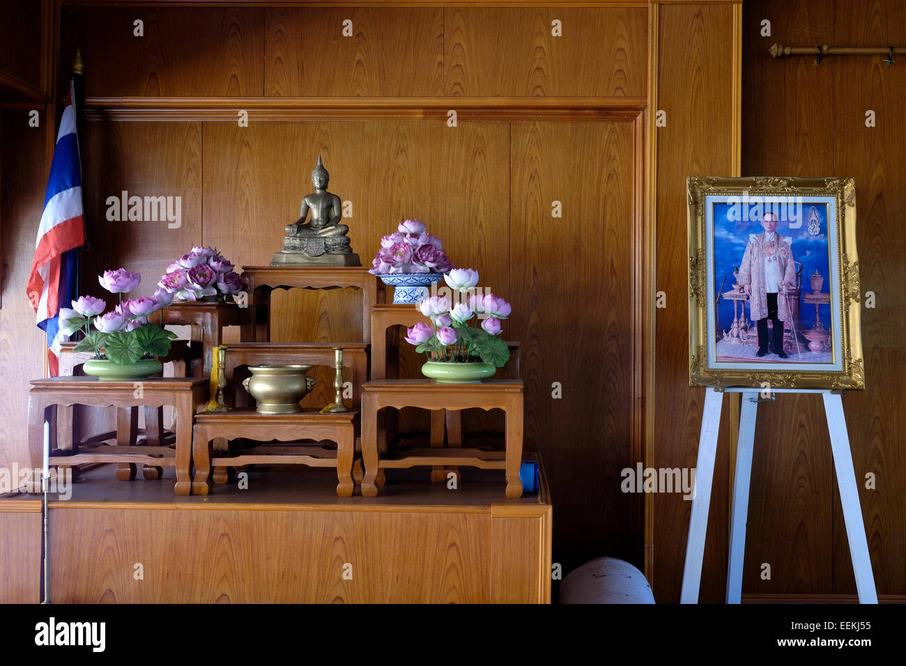 Un portrait encadré du roi Bhumibol Adulyadej (Rama IX) est affiché sur un chevalet à côté d'un autel avec statue de Bouddha et offrande de lotus à côté d'un bol cérémoniel, symbolisant le respect et la pureté dans la tradition bouddhiste. Dans la cour du temple Wat Neramit Wipattasana situé sur une colline près de Phra That si Song Rak dans le district de Dan SAI dans la partie ouest de la province de Loei, au nord-est de la Thaïlande Banque D'Images