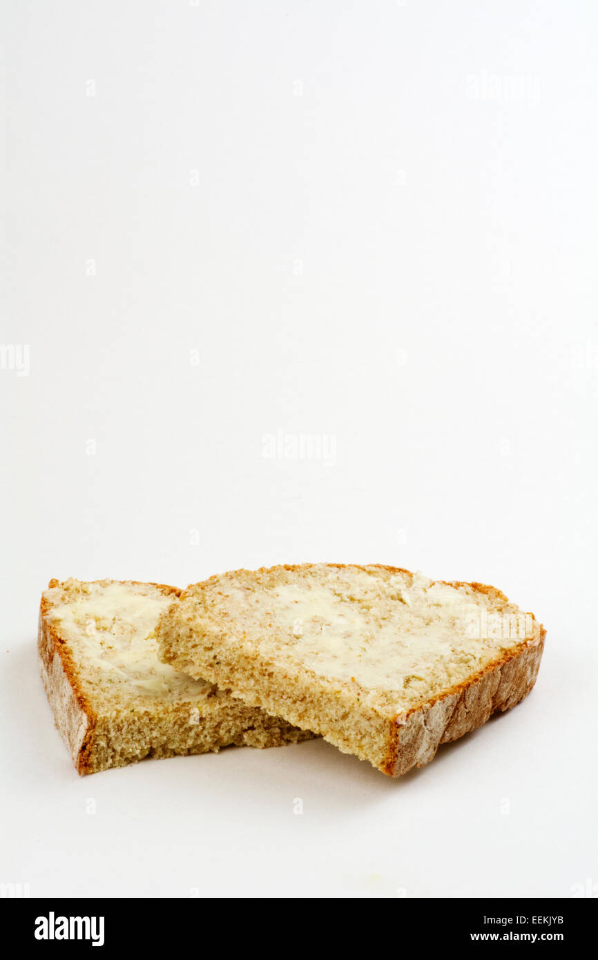 Tranches de pain beurrée de soude sur un fond blanc Banque D'Images