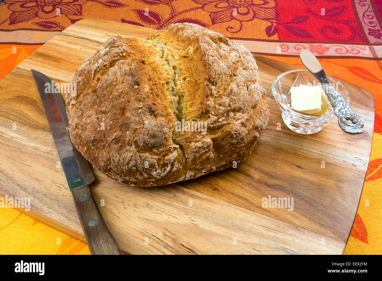 Miche de pain de soude sur une planche à découper, un plat de beurre Banque D'Images