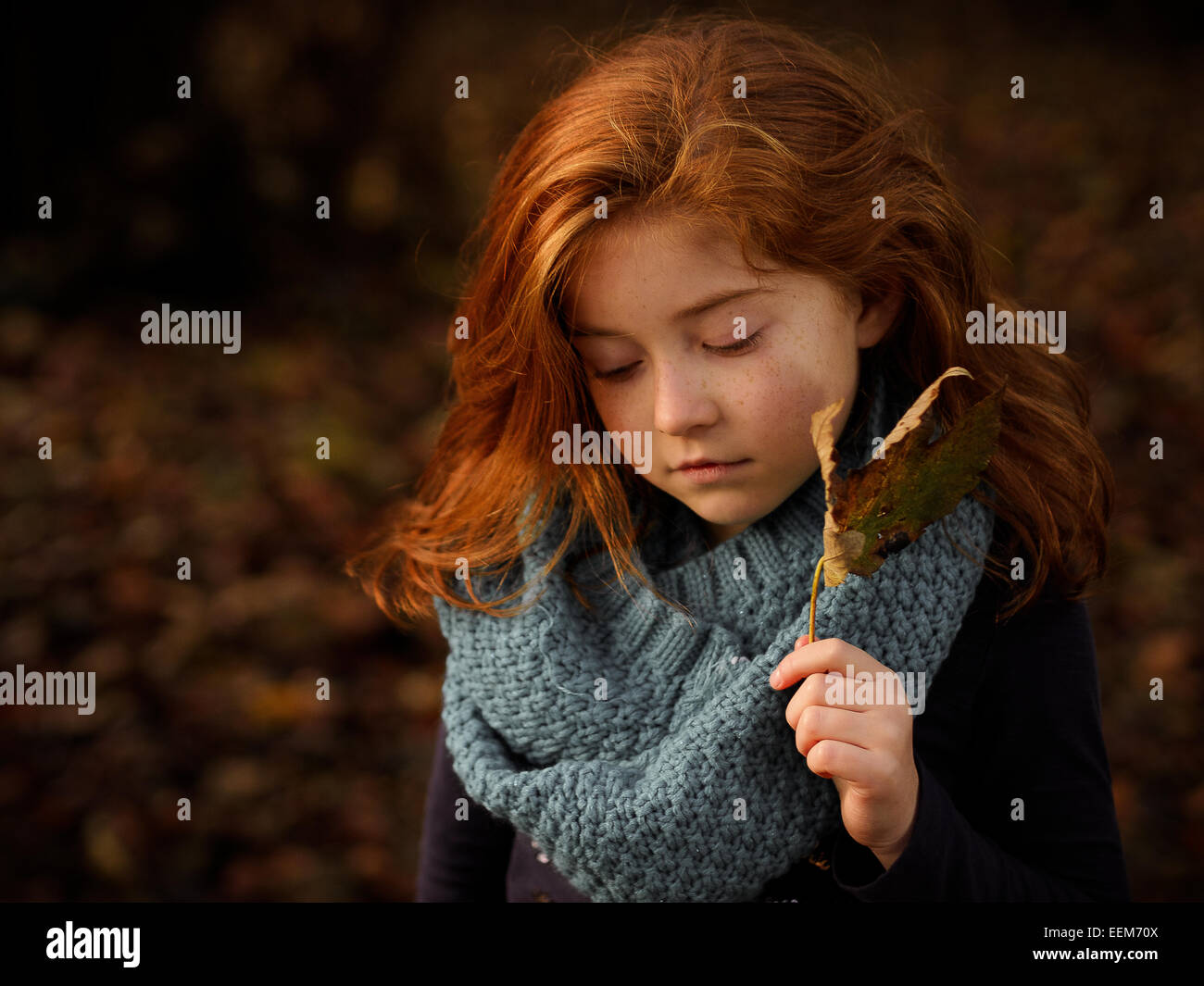 Red haired girl holding autumn leaf Banque D'Images