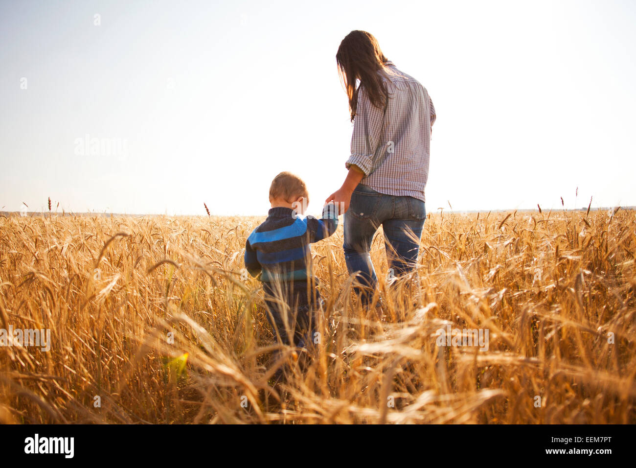 Caucasian mother and son walking in rural field Banque D'Images