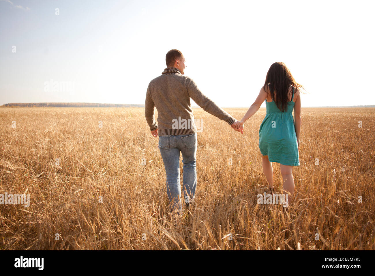 Caucasian couple holding hands in rural field Banque D'Images