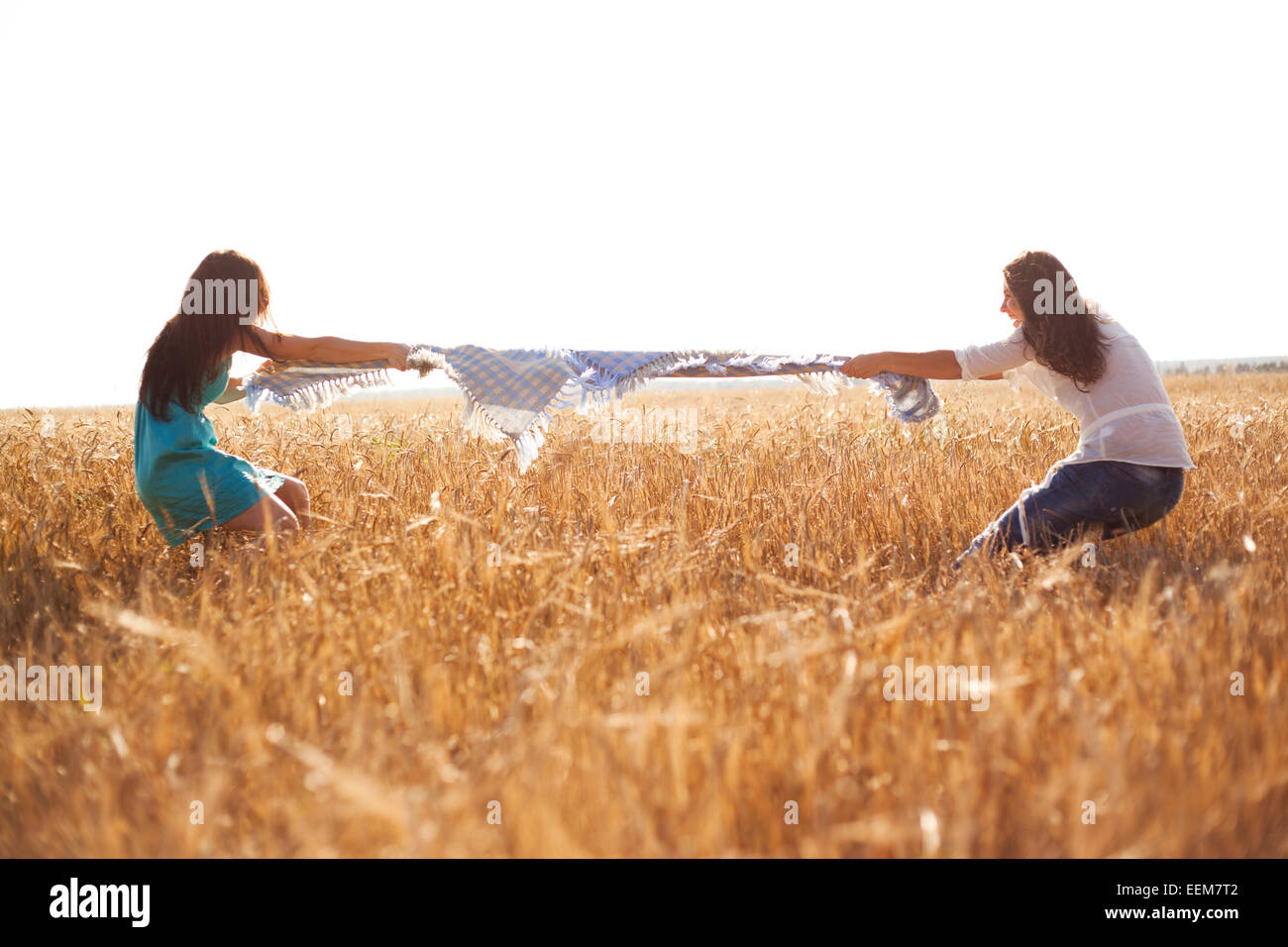 Les femmes de race blanche jouant à la corde in rural field Banque D'Images