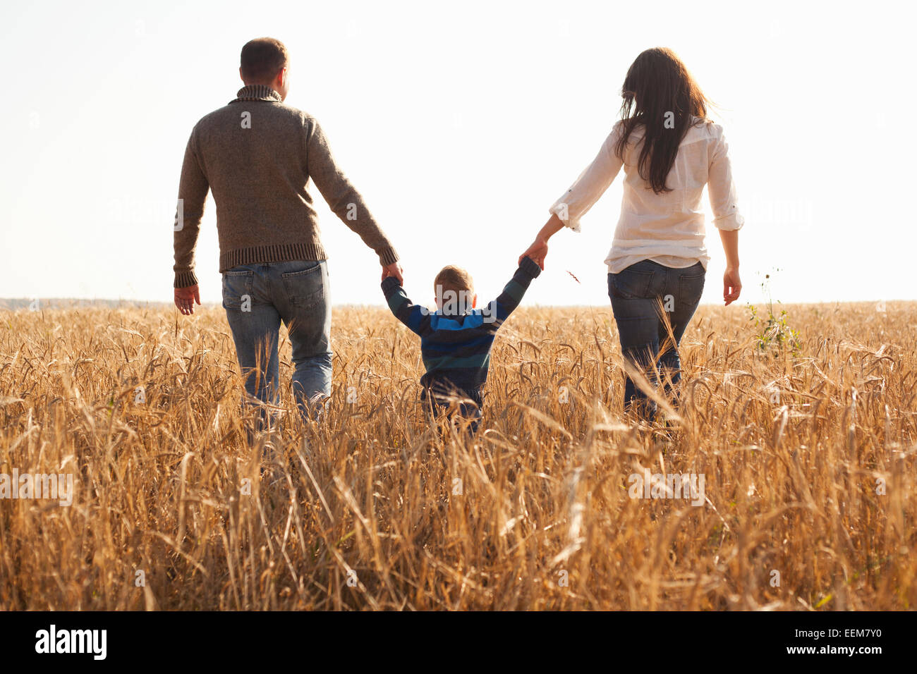 Caucasian family walking in rural field Banque D'Images