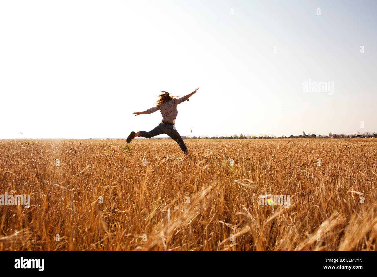 Caucasian woman jumping for joy in rural field Banque D'Images