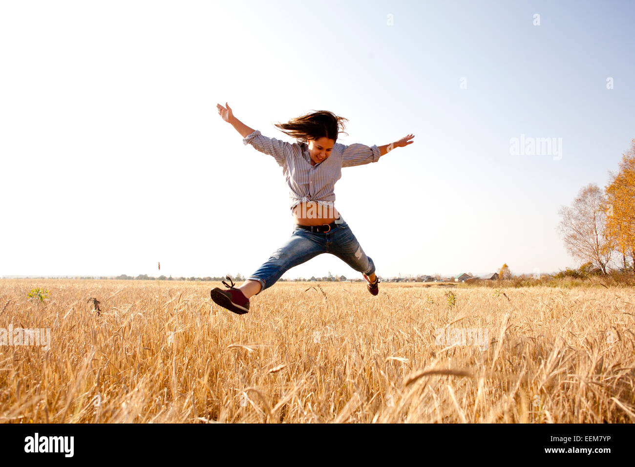 Caucasian woman jumping for joy in rural field Banque D'Images