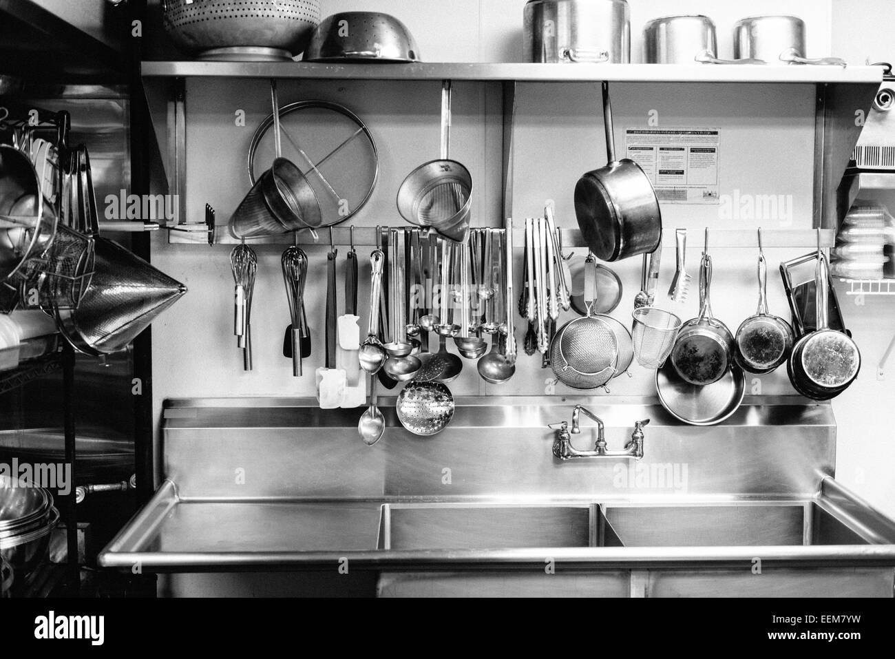 Vaisselle suspendues au-dessus de l'évier de cuisine commerciale Banque D'Images