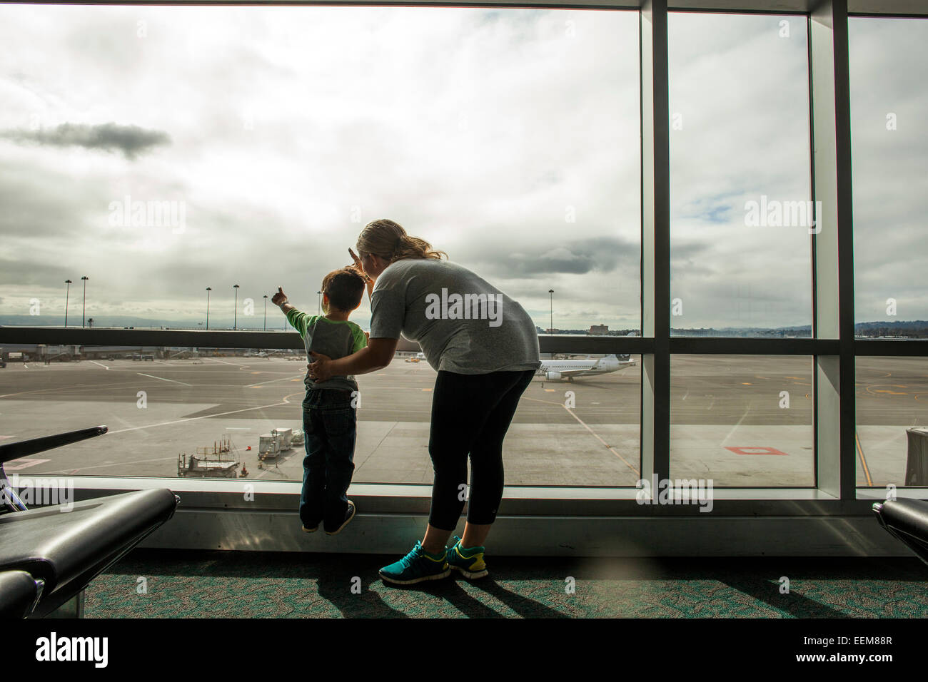Mère et fils à la fenêtre de l'aéroport hors Banque D'Images