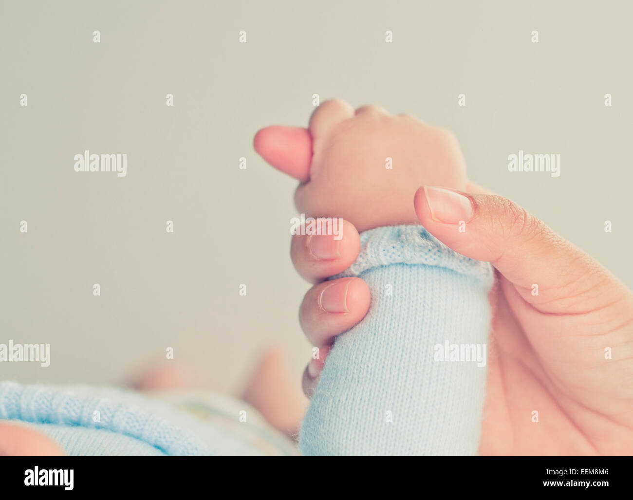 Gros plan de la main d'une mère tenant la main d'un bébé garçon Banque D'Images