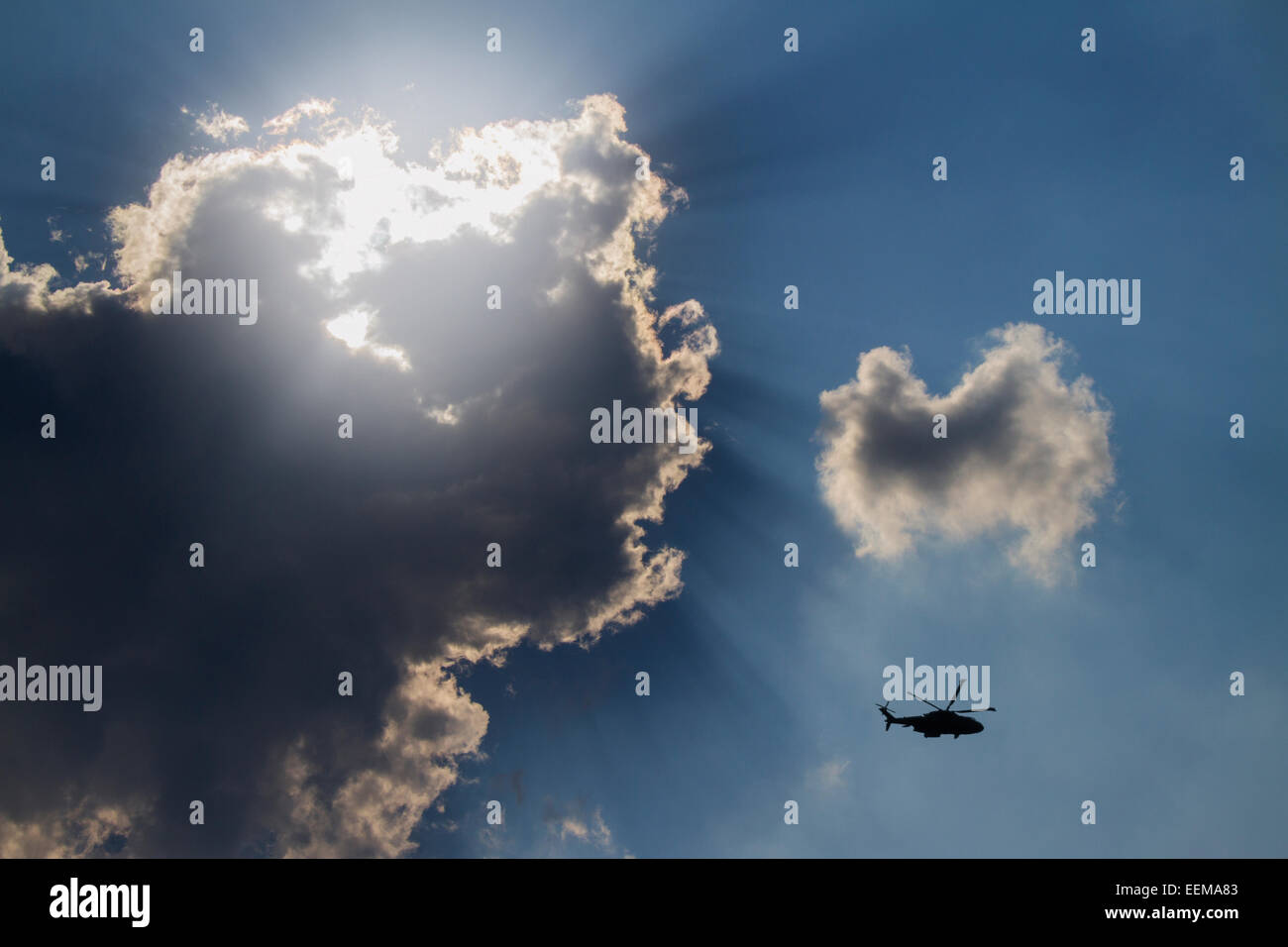 Low angle view of hélicoptère volant à ciel nuageux Banque D'Images