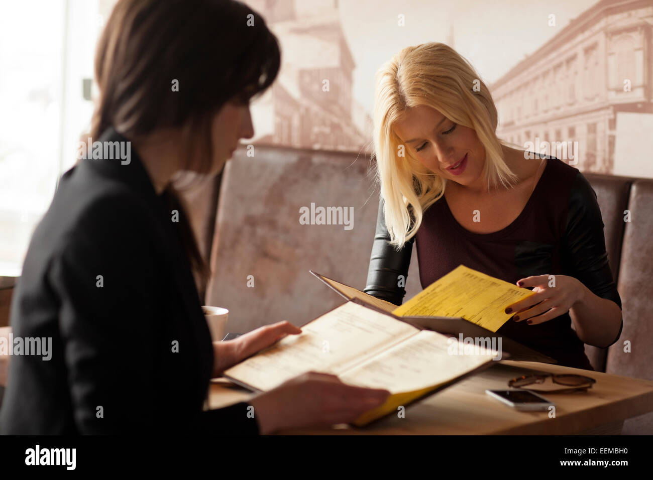 Les femmes lecture des menus in cafe Banque D'Images