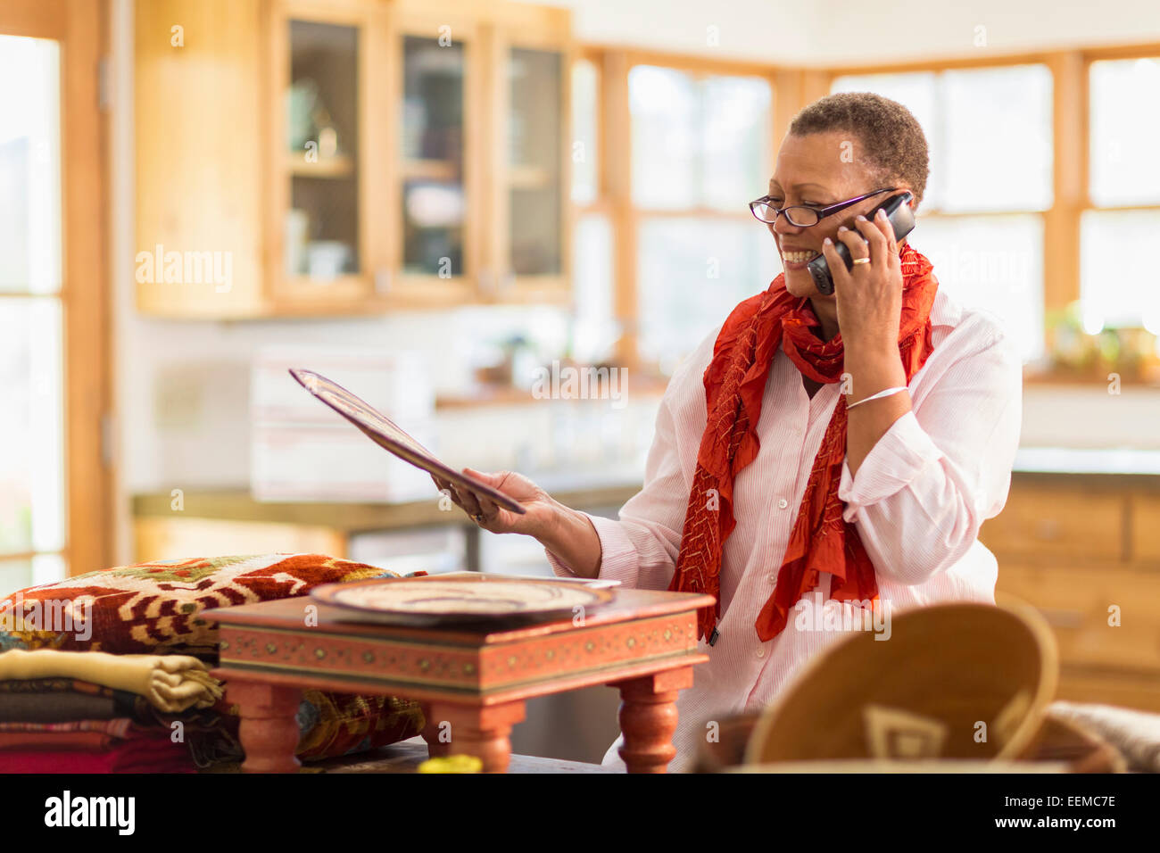 Plus mixed race Woman talking on telephone in home office Banque D'Images