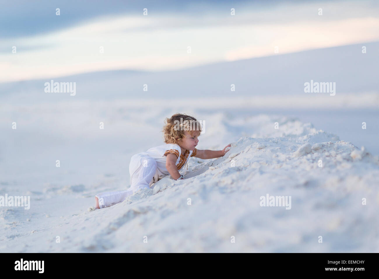 Young boy climbing sand dune Banque D'Images