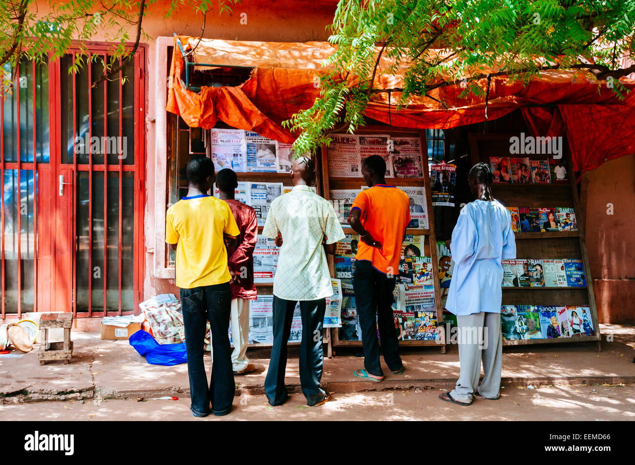 Les jeunes hommes de lire les journaux dans un kiosque à journaux, Bamako, Mali. Banque D'Images