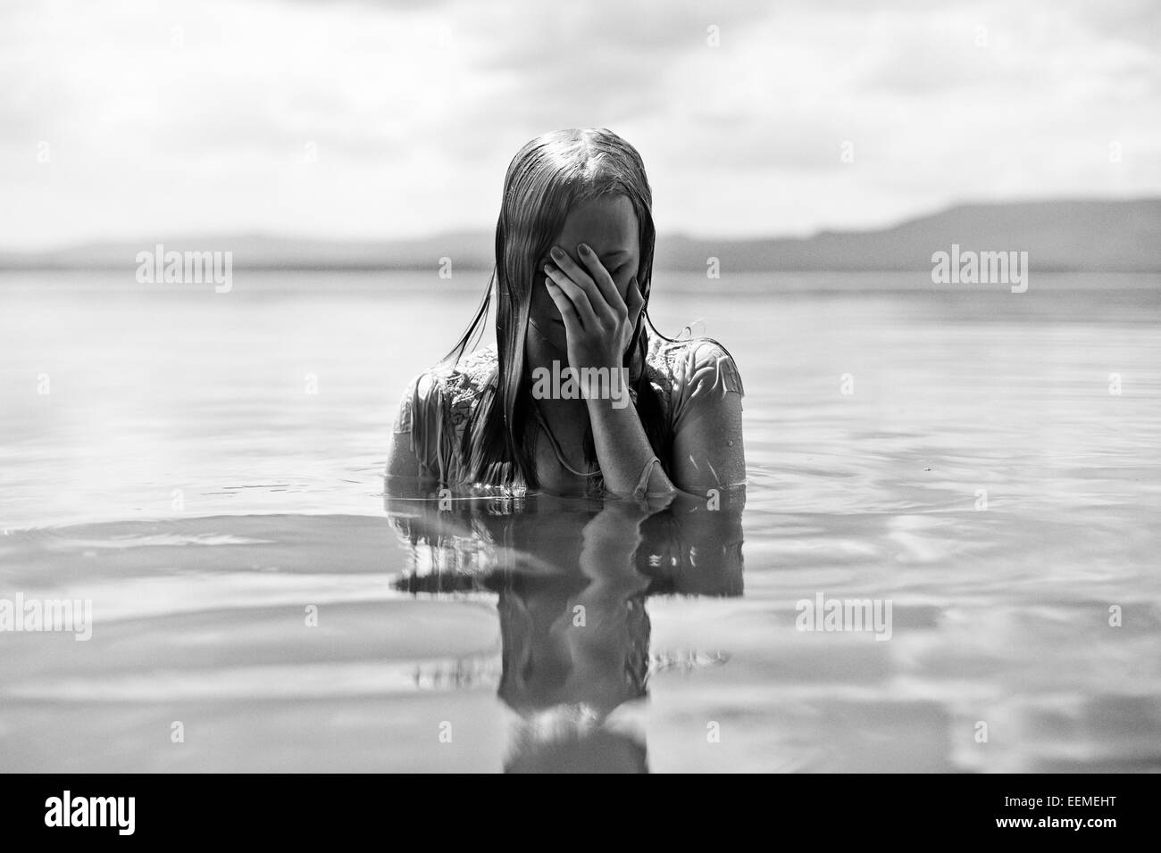 Caucasian woman covering her face au lac Banque D'Images