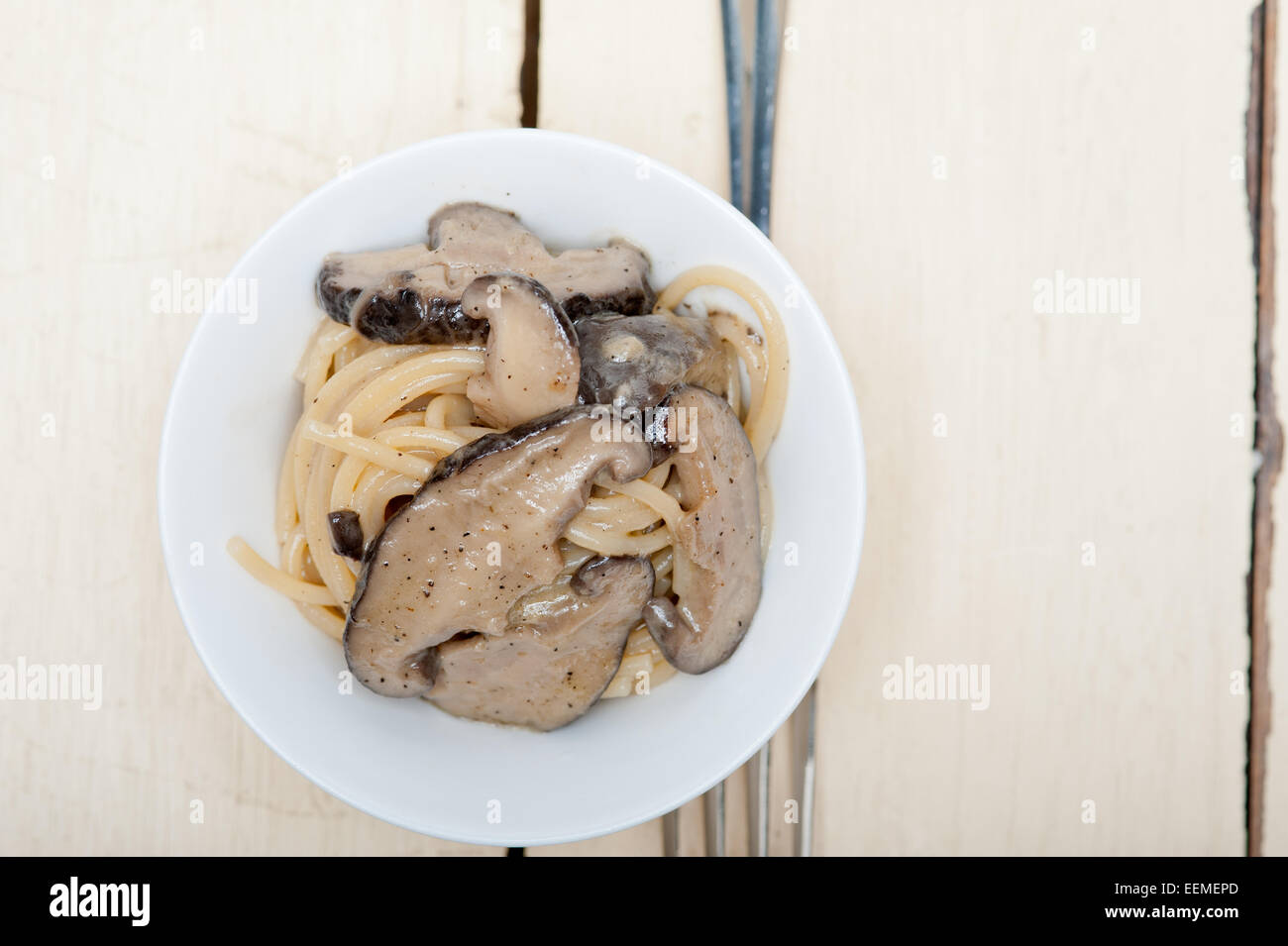Les pâtes spaghetti italien et des champignons sauvages sur table en bois rustique Banque D'Images