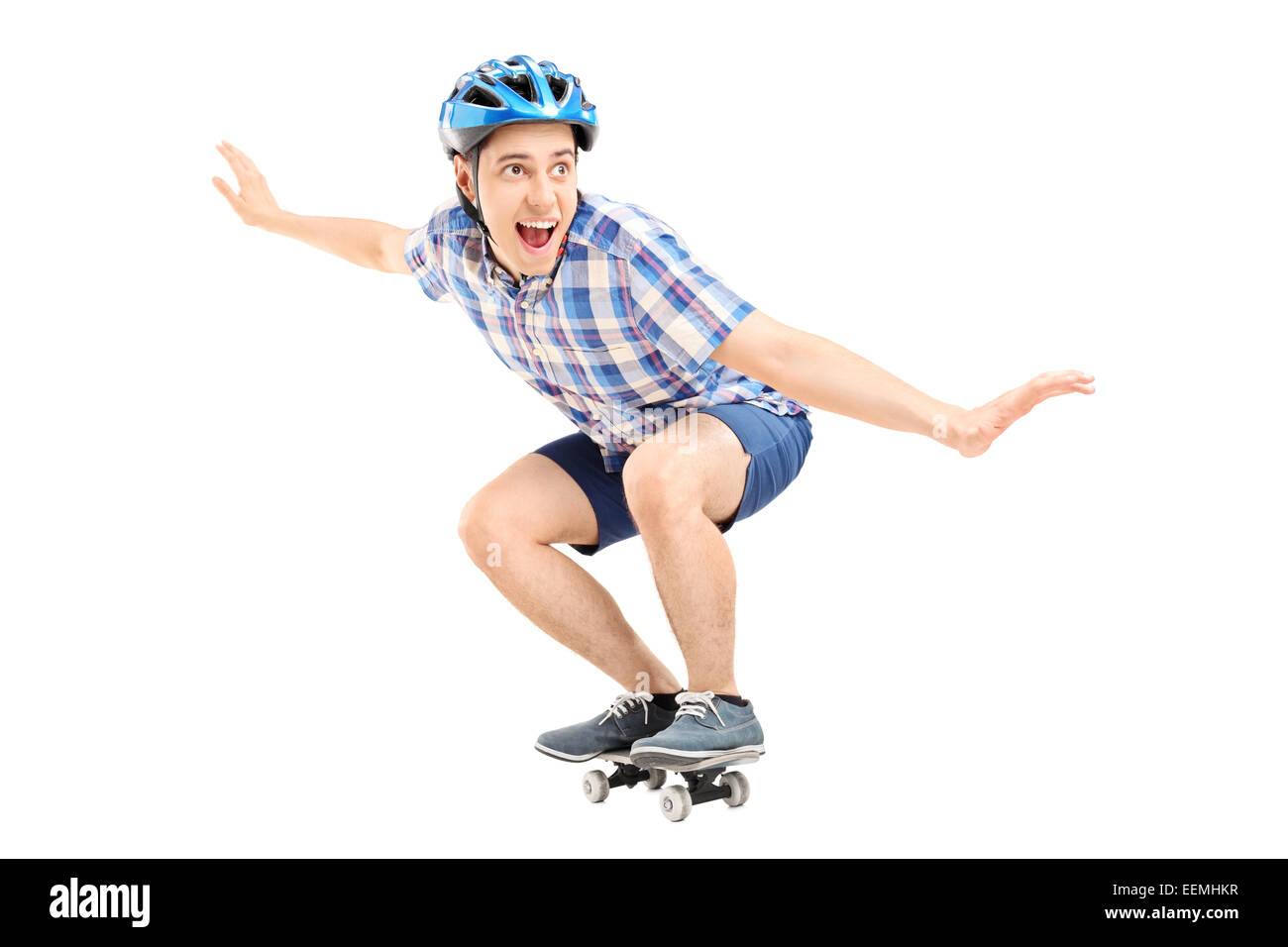 Joyful guy riding un petit skateboard isolé sur fond blanc Banque D'Images