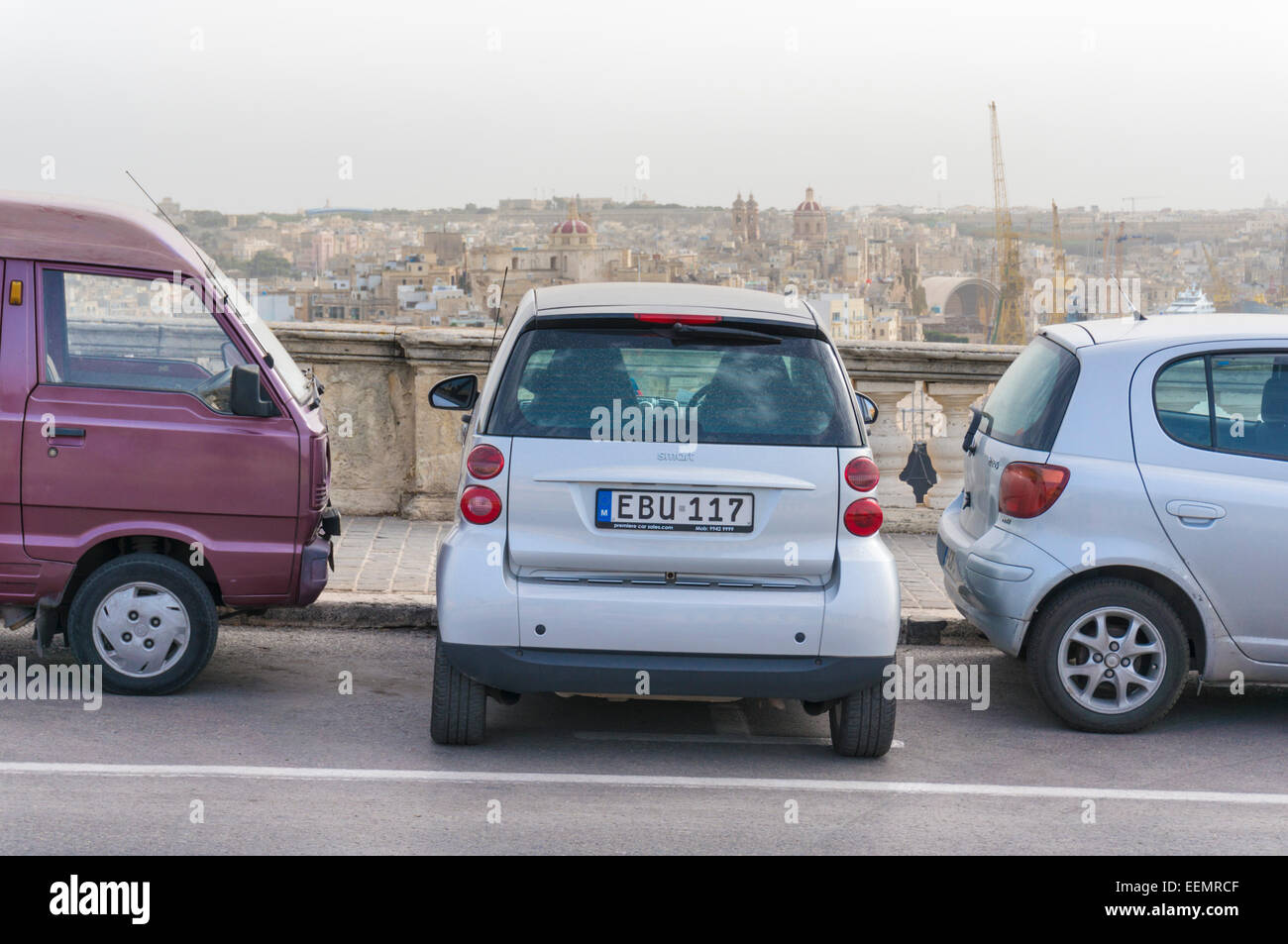 Smart voiture garée entre dans petit espace entre deux voitures VallettaMalta l'Europe de l'UE Banque D'Images