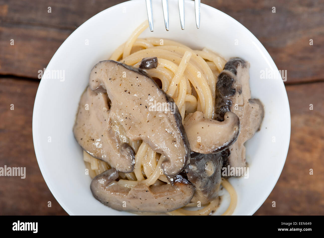 Les pâtes spaghetti italien et des champignons sauvages sur table en bois rustique Banque D'Images