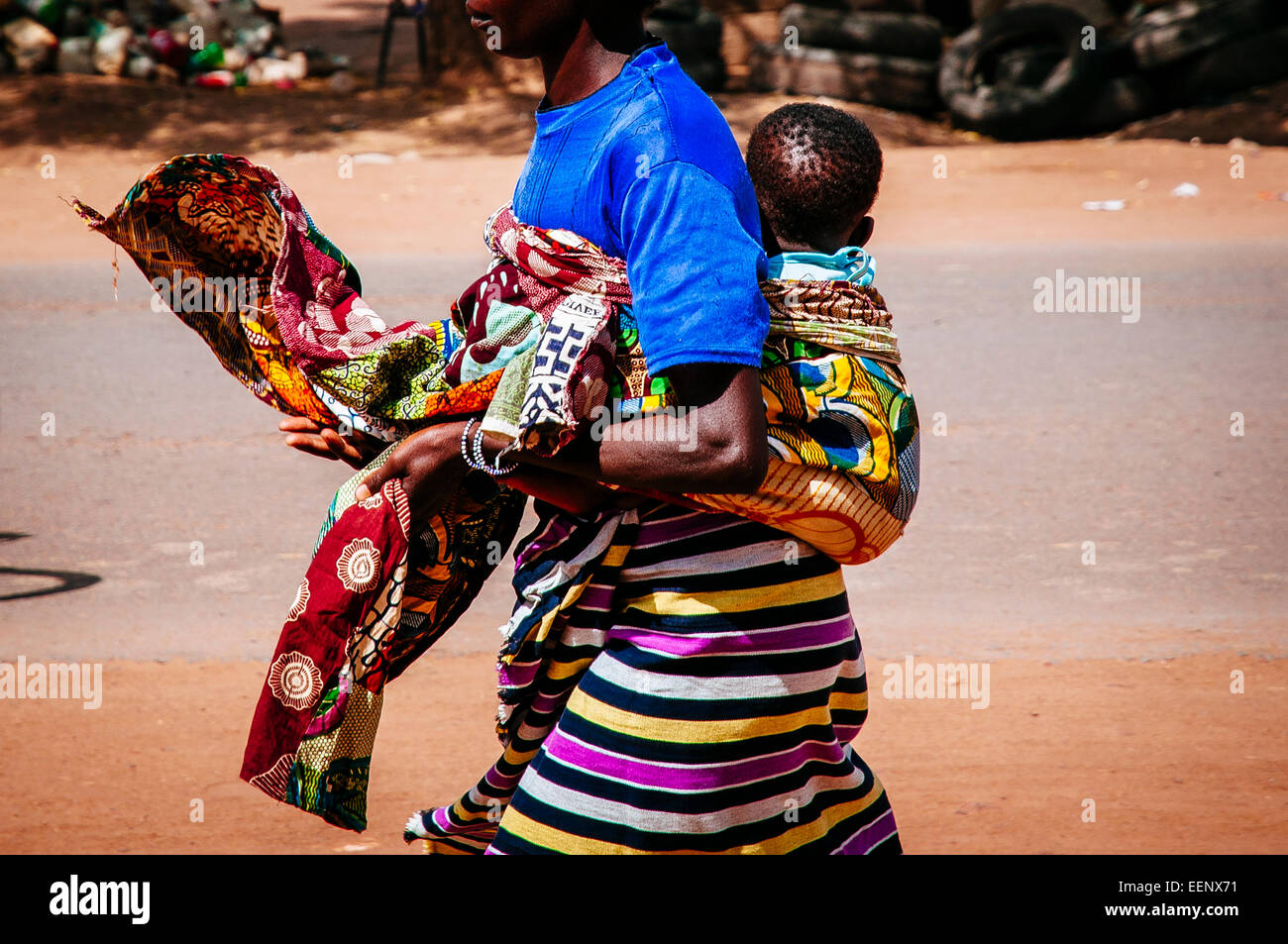 Femme marche tout en portant le bébé sur le dos, le Burkina Faso. Banque D'Images