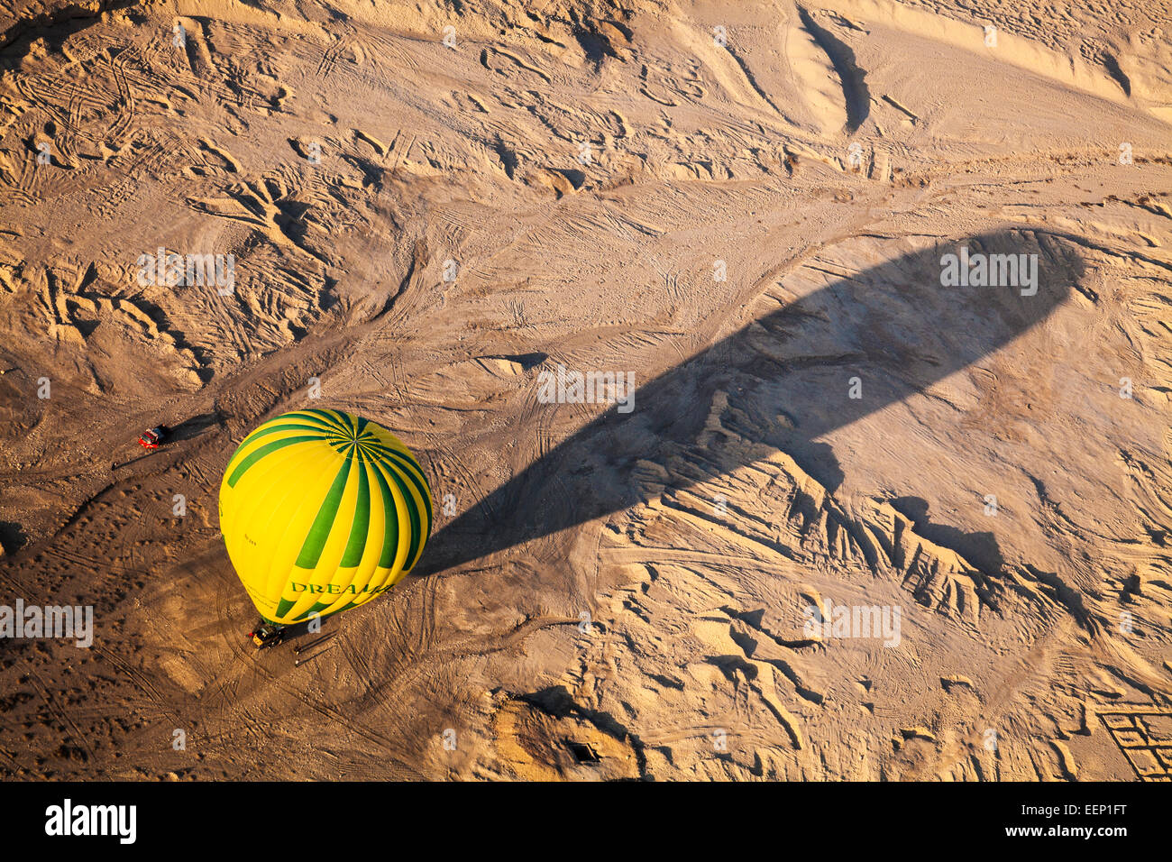 Un ballon à air chaud jette une ombre portée comme il terres dans le désert sur la rive ouest du Nil en Egypte. Banque D'Images