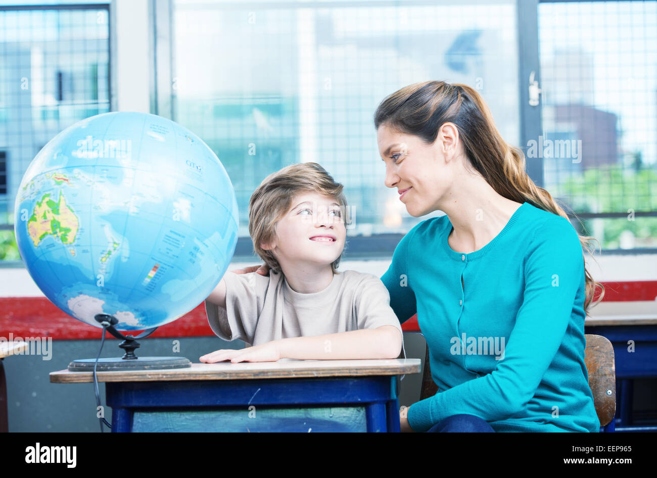 Happy kid a l'école primaire avec l'apprentissage de la géographie du monde enseignant. Banque D'Images