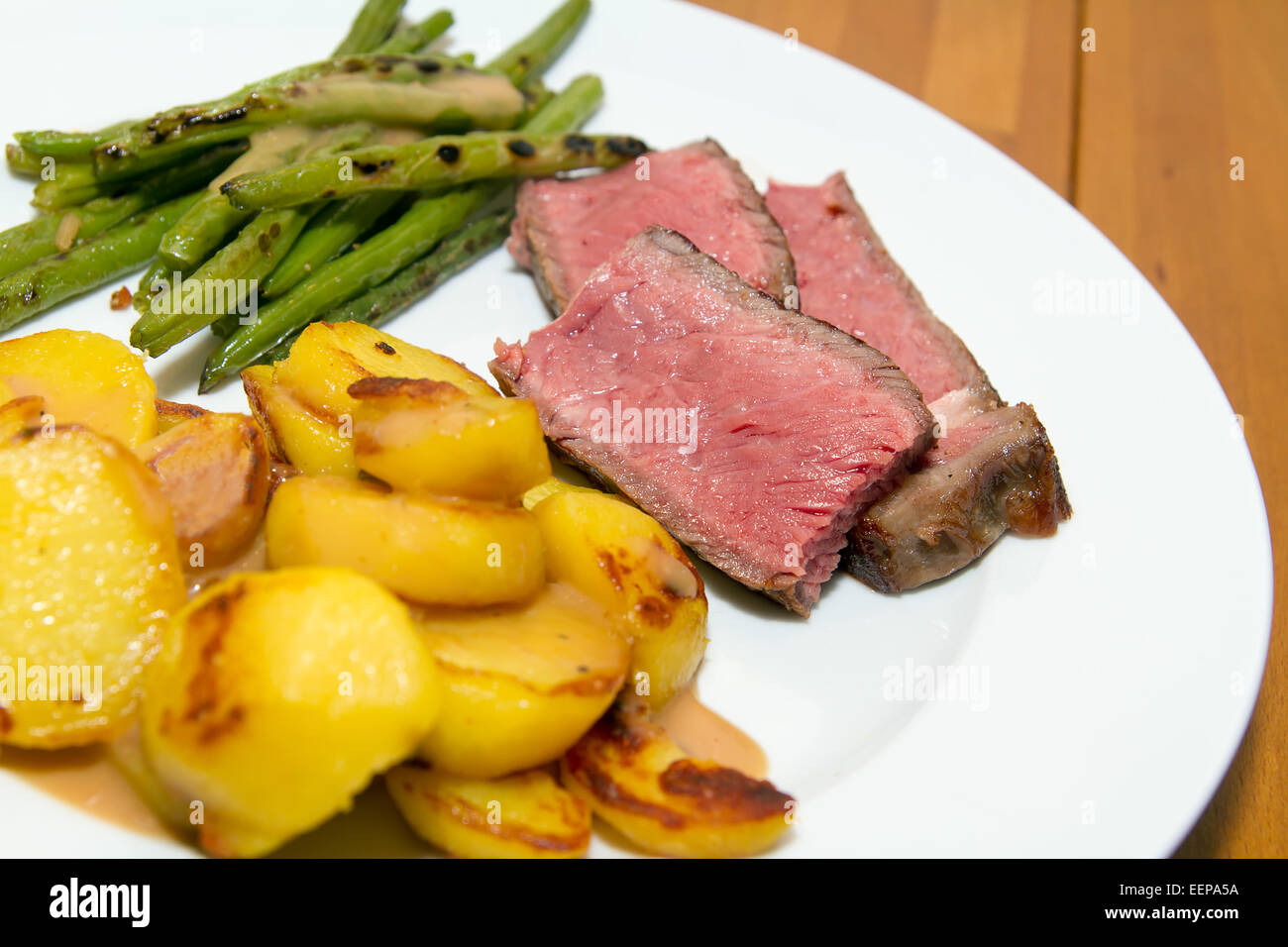 Rôti de boeuf / steak avec pommes de terre sautées et des haricots Banque D'Images