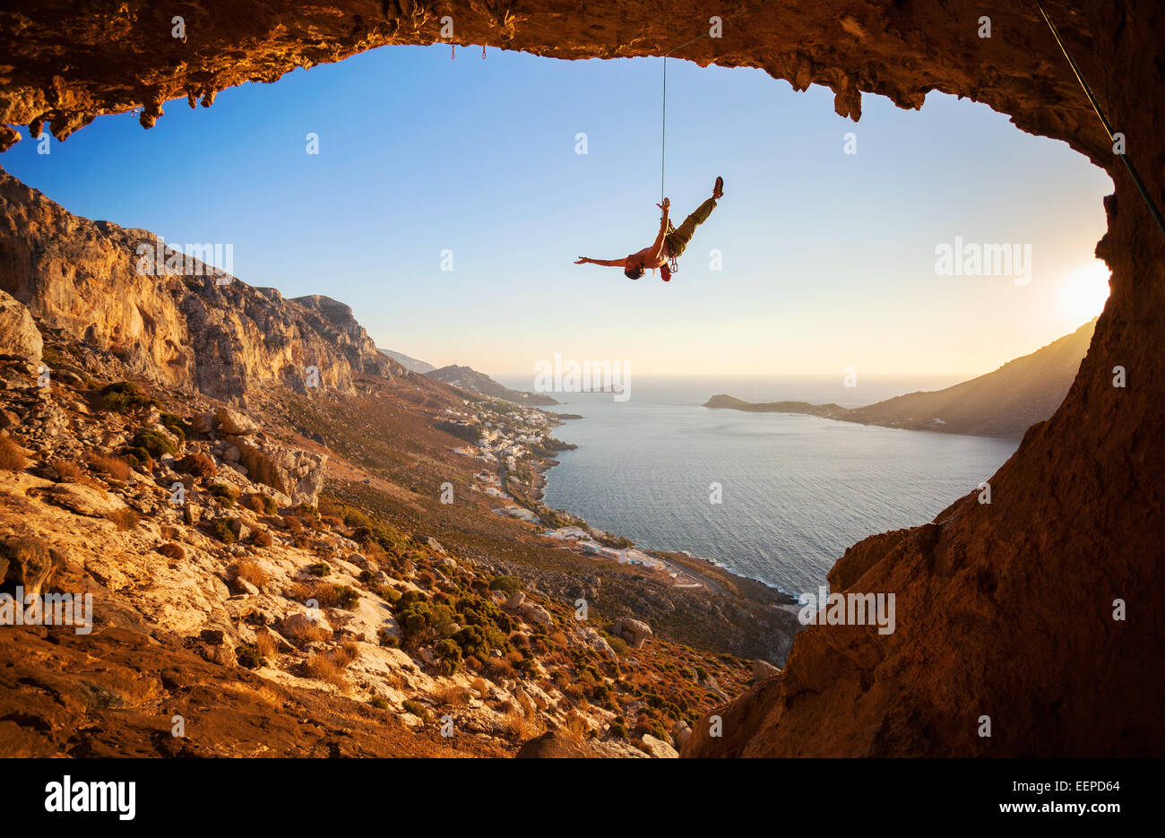 Rock climber hanging sur corde tout en escalade Banque D'Images