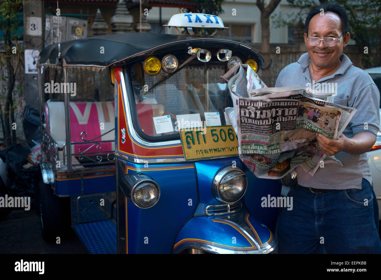 Tuk Tuk driver lire le journal. Tuk-tuks ou 'sam lor' (trois roues) utilisé pour être le favori de tous moyens de locomotion dans Banque D'Images