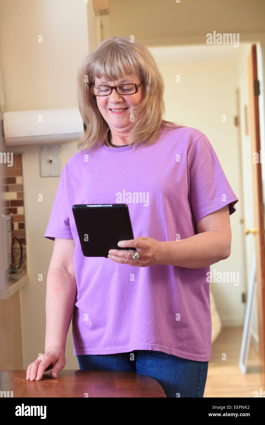 Femme avec le trouble bipolaire qui vivent à la maison et en utilisant son tablet Banque D'Images