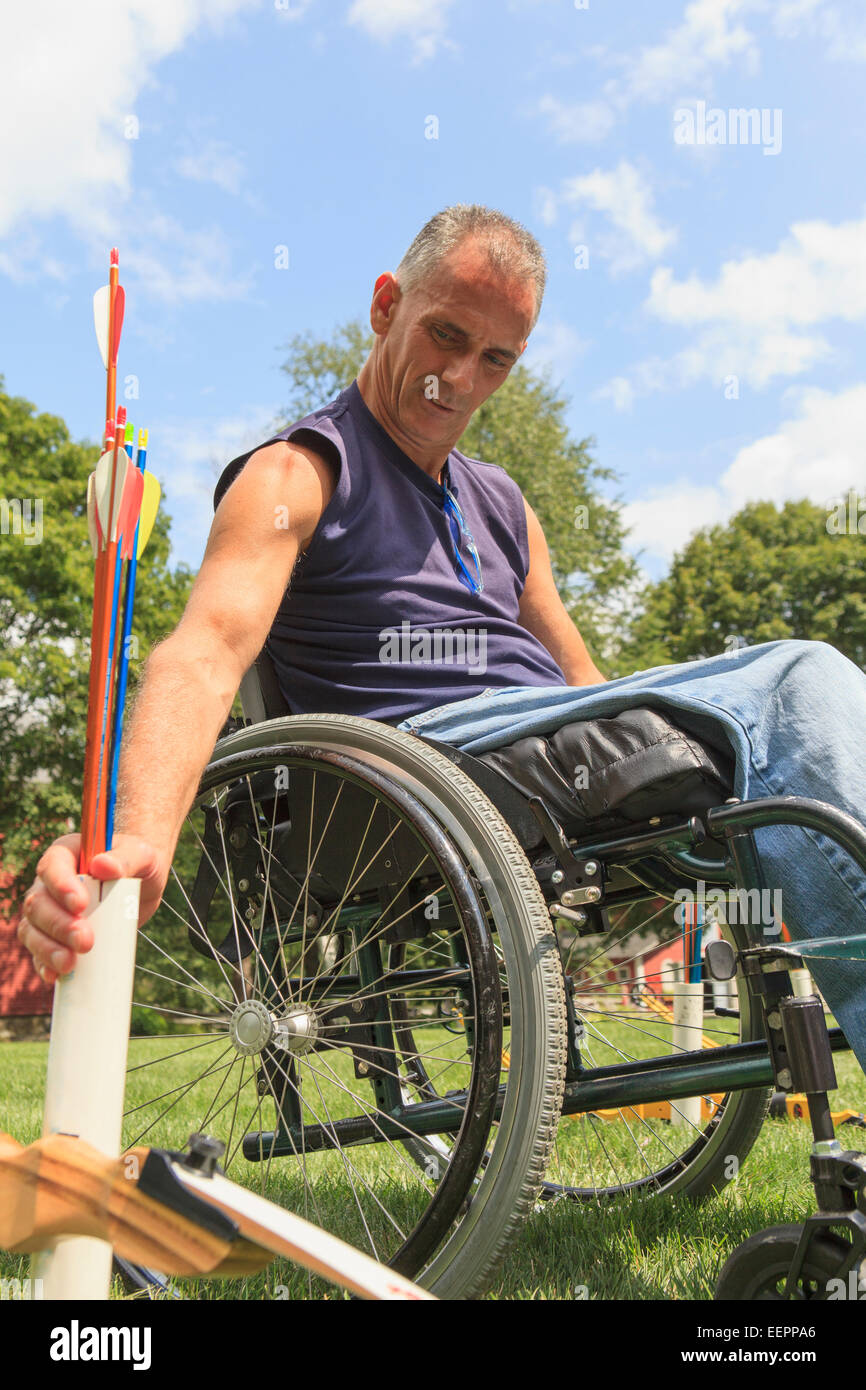 L'homme avec de la moelle épinière en fauteuil roulant pour la pratique du tir à l'établissement Banque D'Images