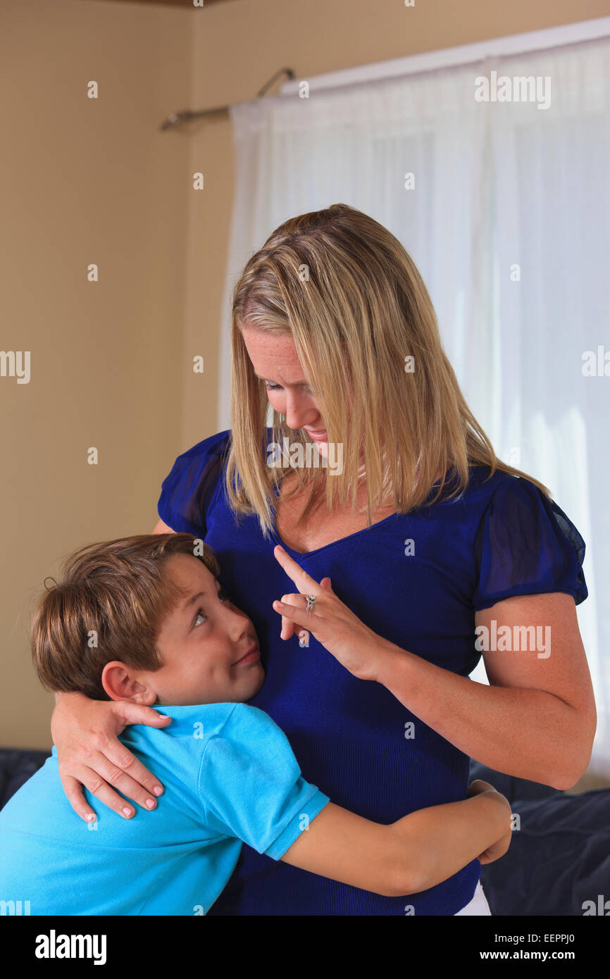 Mère et fils malentendants hugging et la signature "I love you" dans la langue des signes américaine Banque D'Images