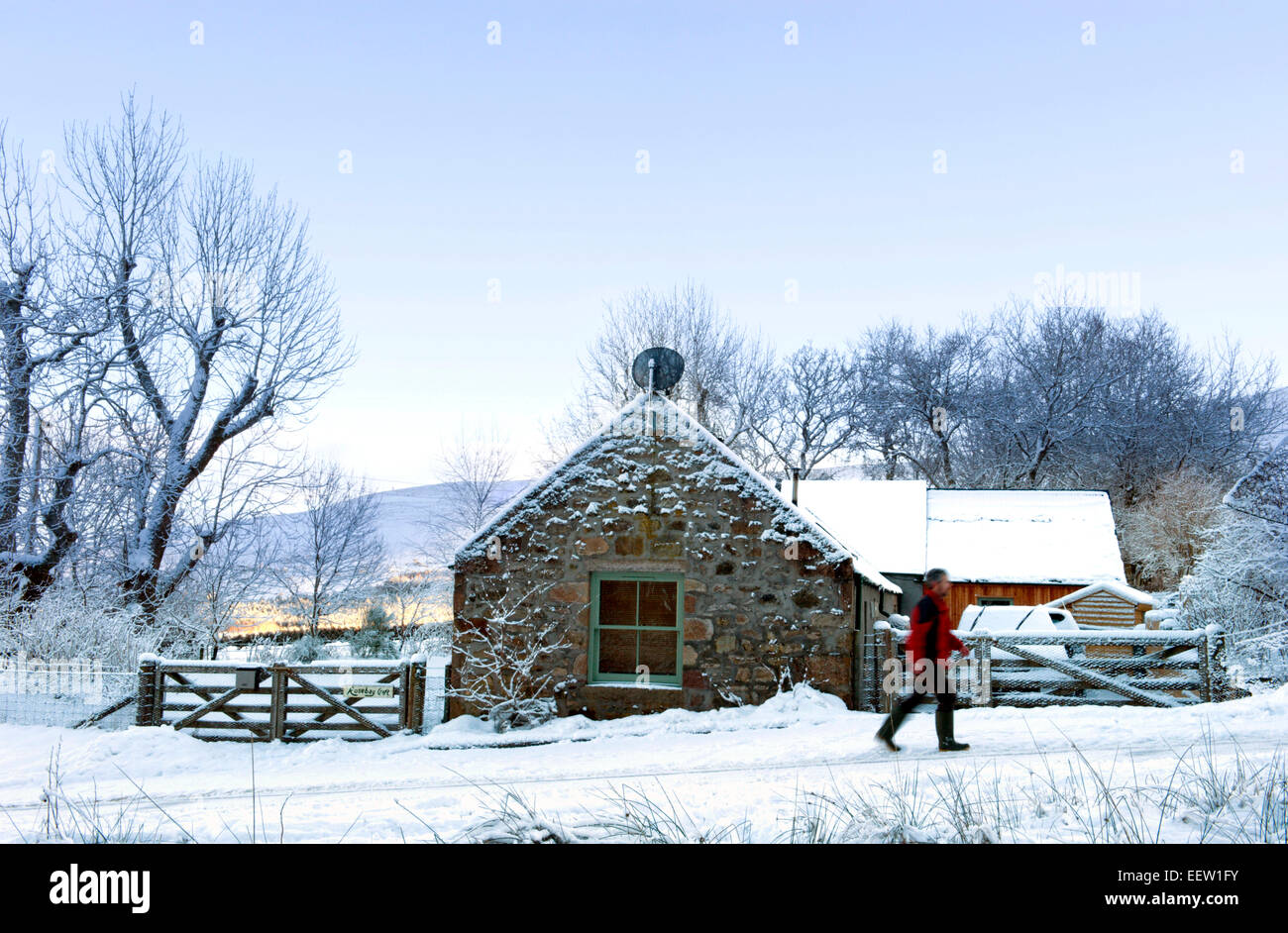 Une famille walker passe un converti croft en Ecosse recouvert de neige de l'hiver Banque D'Images