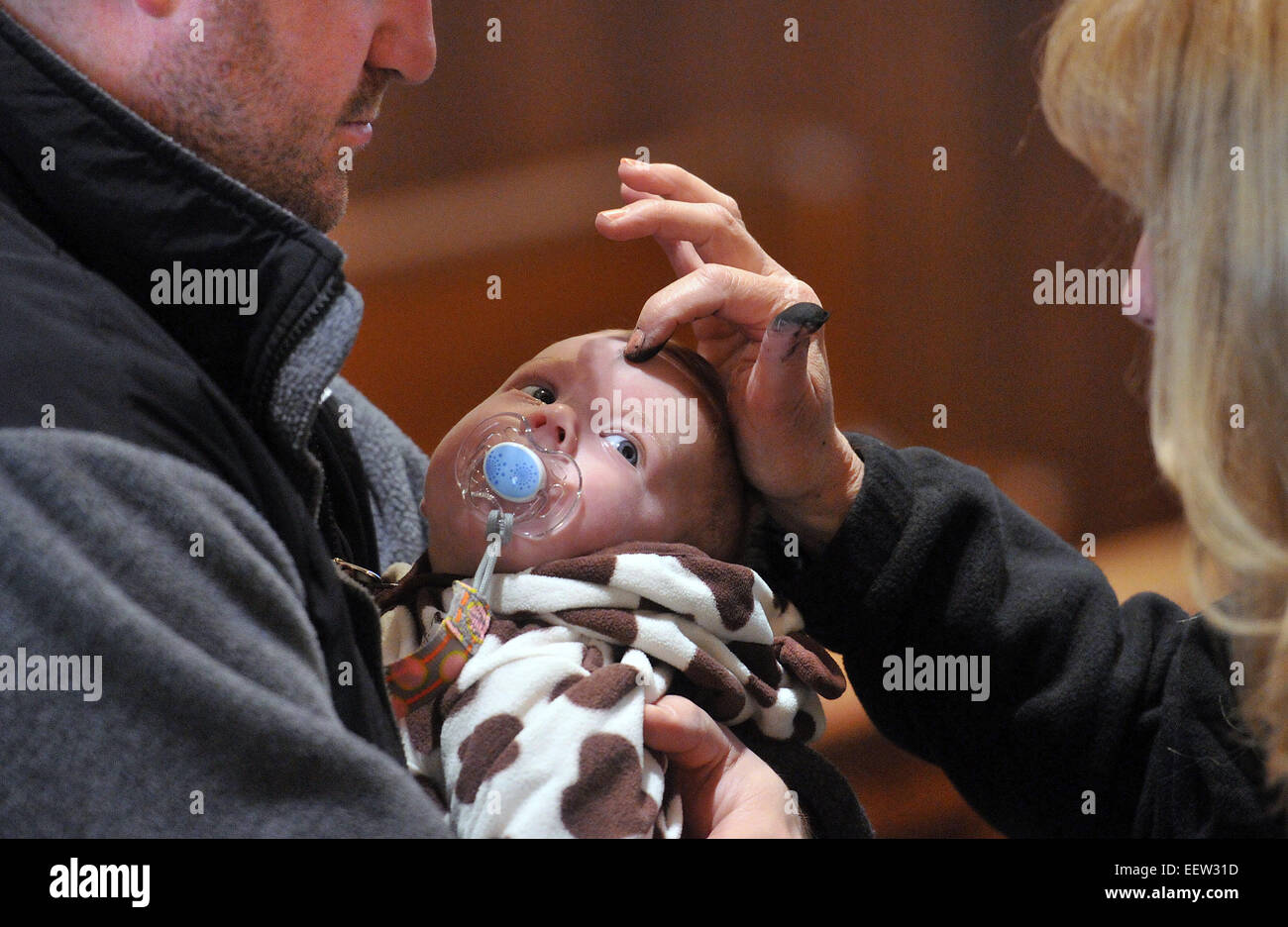 New Haven, CT USA- 3-month-old Mara Picciano a cendres appliqué par ministre eucharistique, Charlene Armellino durant le mercredi des cendres des services à l'église Sainte Bernadette à New Haven. Holding Picciano est son père, Nick. Qu'ils soient de New Haven. Banque D'Images
