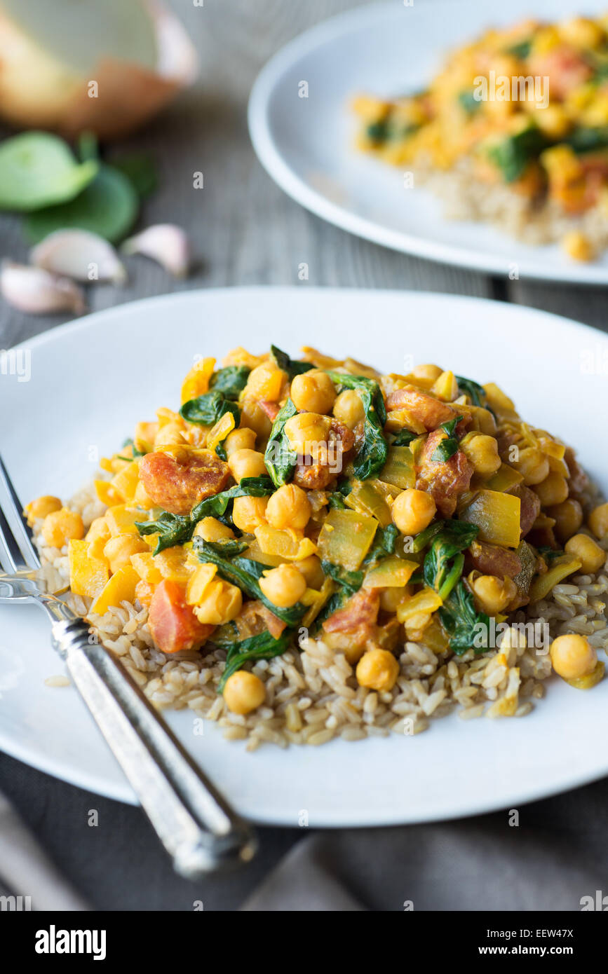 Curry végétarien plat avec les pois chiches et les épinards tomates sur le riz brun Banque D'Images