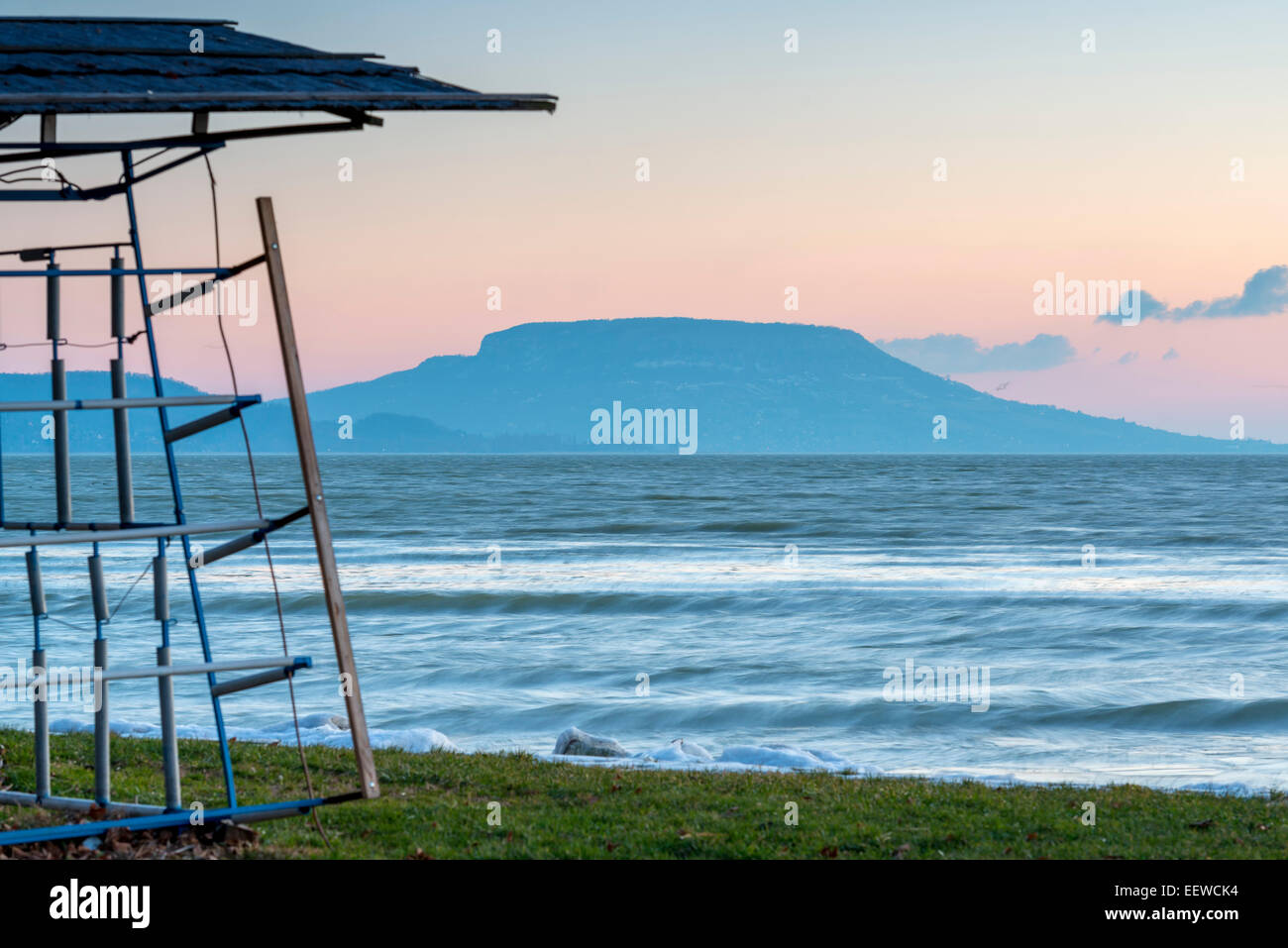 Lac Balaton glacées en hiver par le lever du soleil, la Hongrie. L'Hotel Mountain en arrière-plan. Banque D'Images