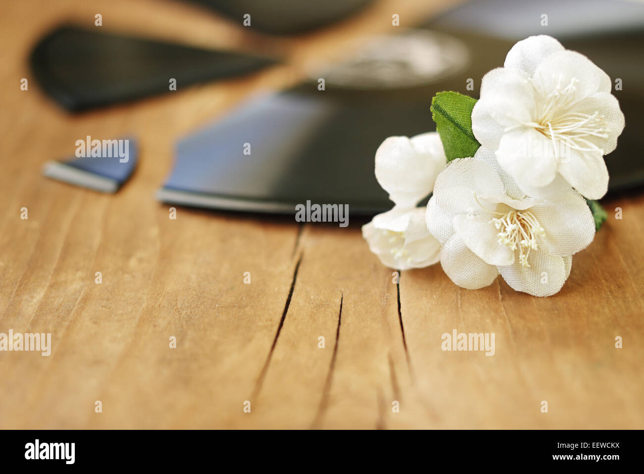 Fleurs de jasmin artificiel sont sur un disque sur un fond de bois Banque D'Images