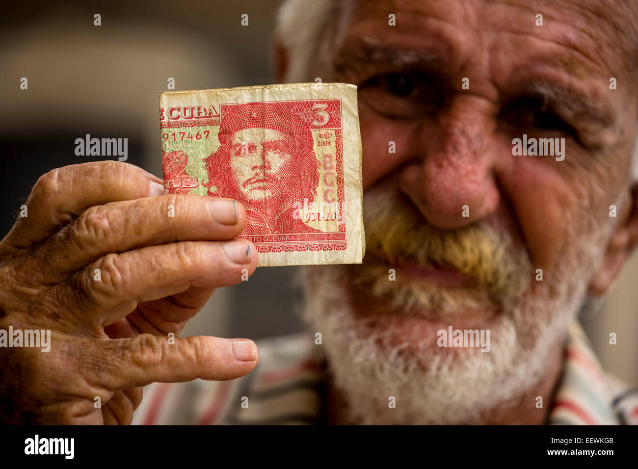 Personnes âgées Cuban man holding a 3-peso bill avec le portrait d'Ernesto Che Guevara en sa main, La Havane, Cuba Banque D'Images