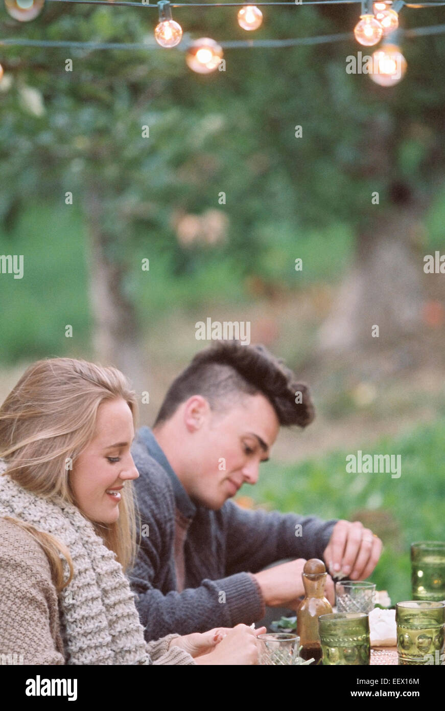 Apple orchard. Couple assis sur le sol Banque D'Images